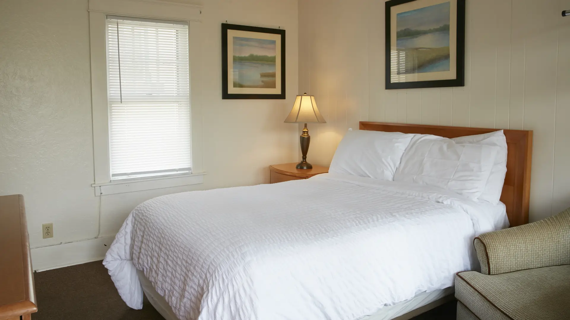 Plush white linens on a king bed in a bright room at The Ashley.