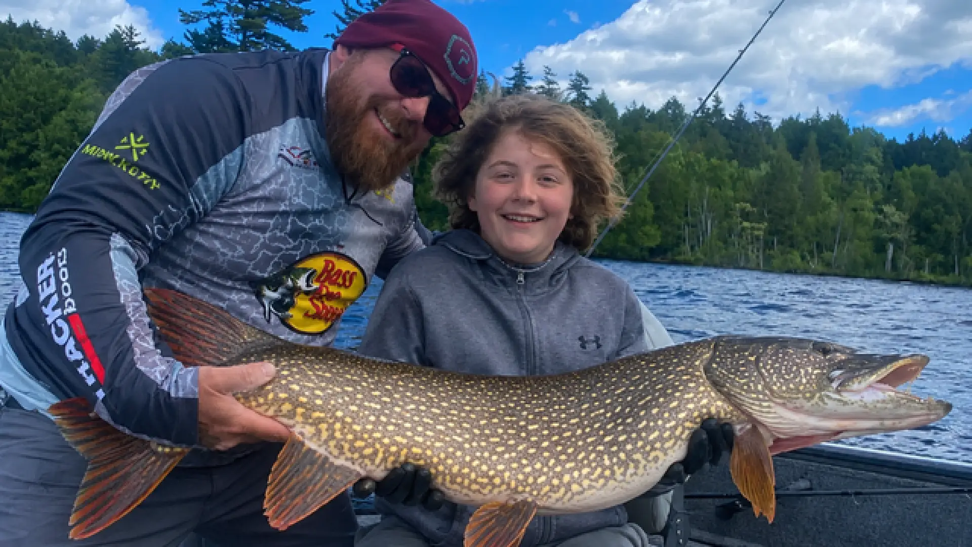 A man and a child hold a pike.