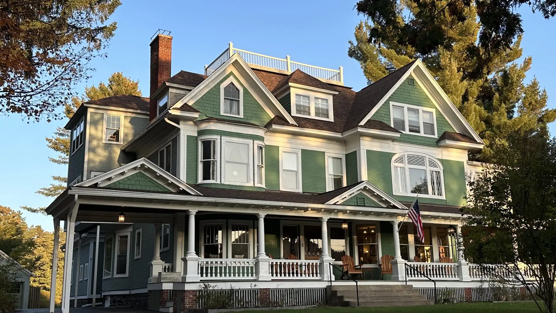 Exterior of the Franklin Manor with elaborate white trim, multiple rooflines and a large covered veranda and widows walk on the roof.