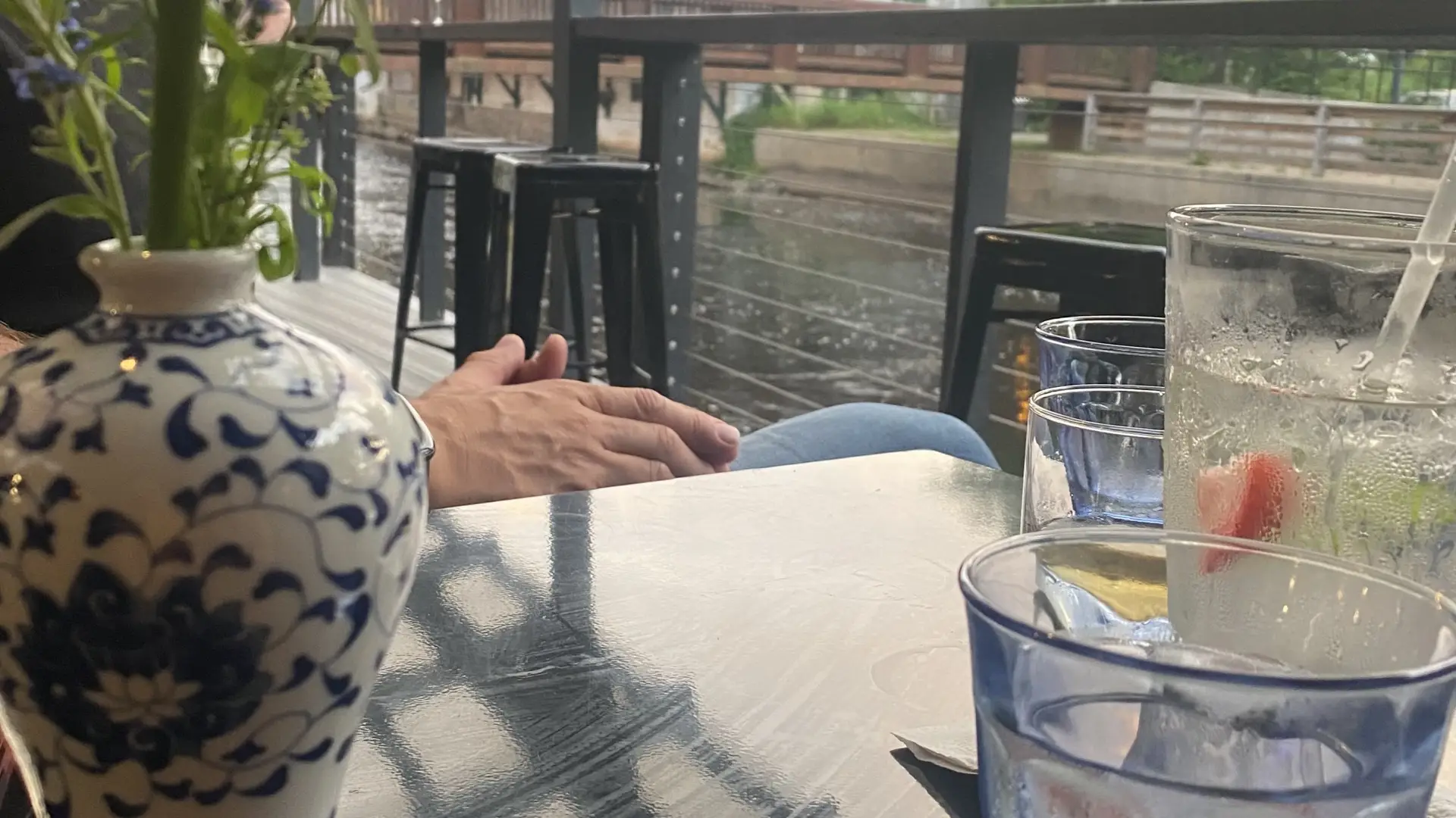 Sitting on the terrace looking over the river with a cocktail on the table 