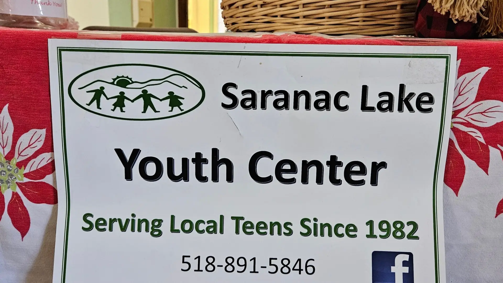 A table with a paper sign with Saranac Lake Youth Center