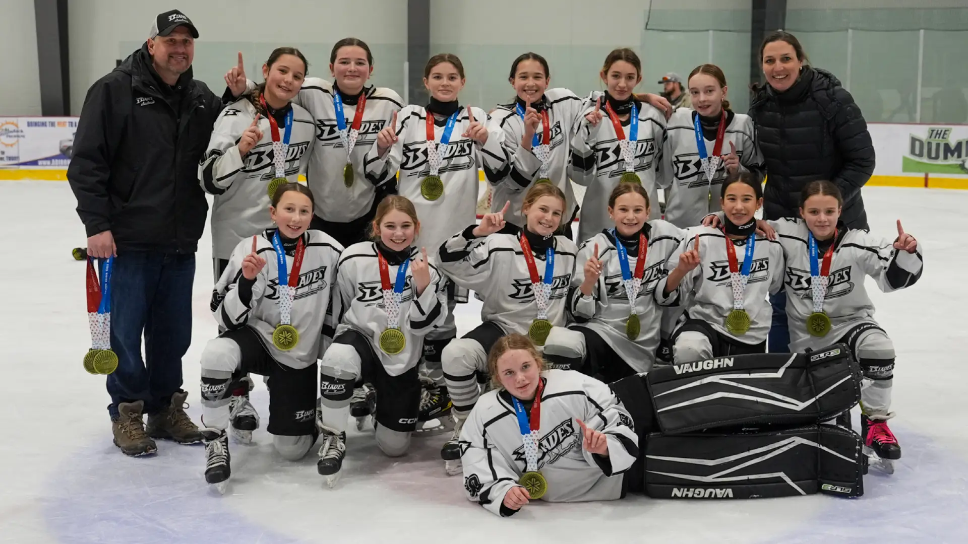 A group of young female hockey players celebrating their victory at the Empire State Winter Games.