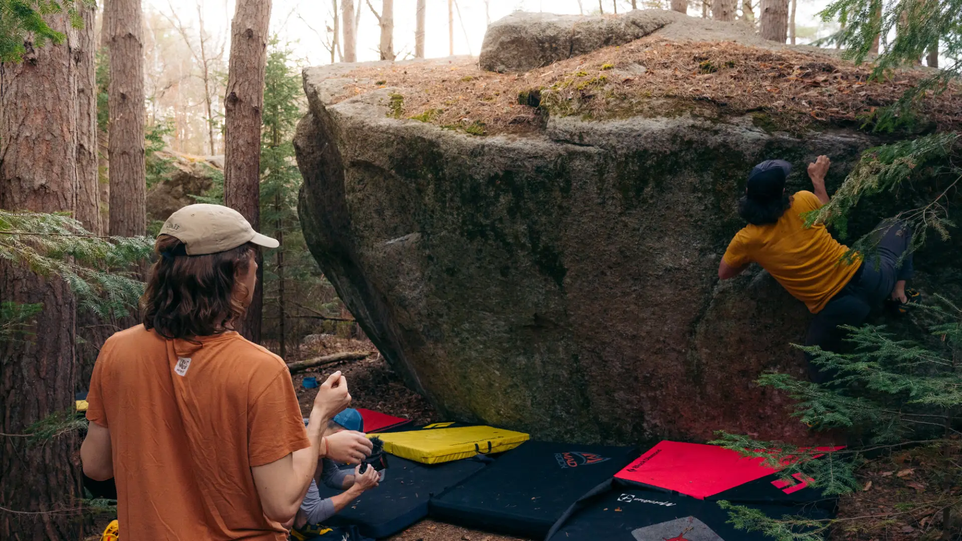A climber boulders across a slanting rock face
