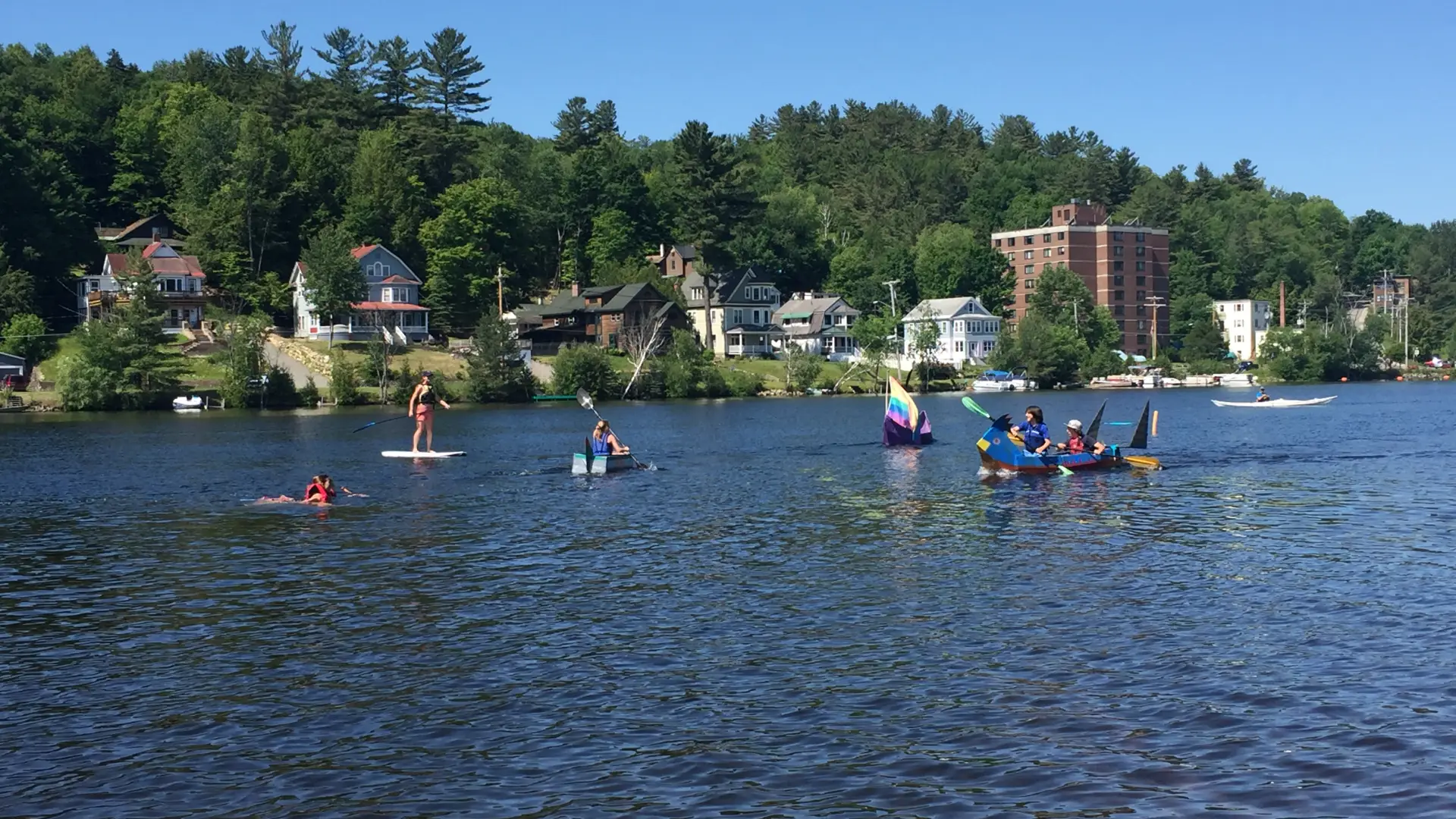 kids in handmade cardboard boats floating on lake flower