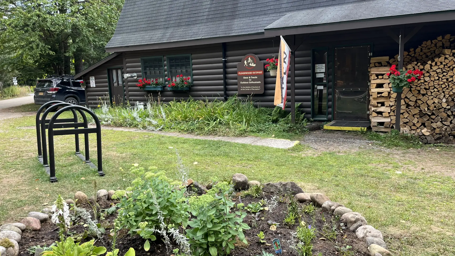 Exterior of the Floodwood Outpost with small garden and bike rack.