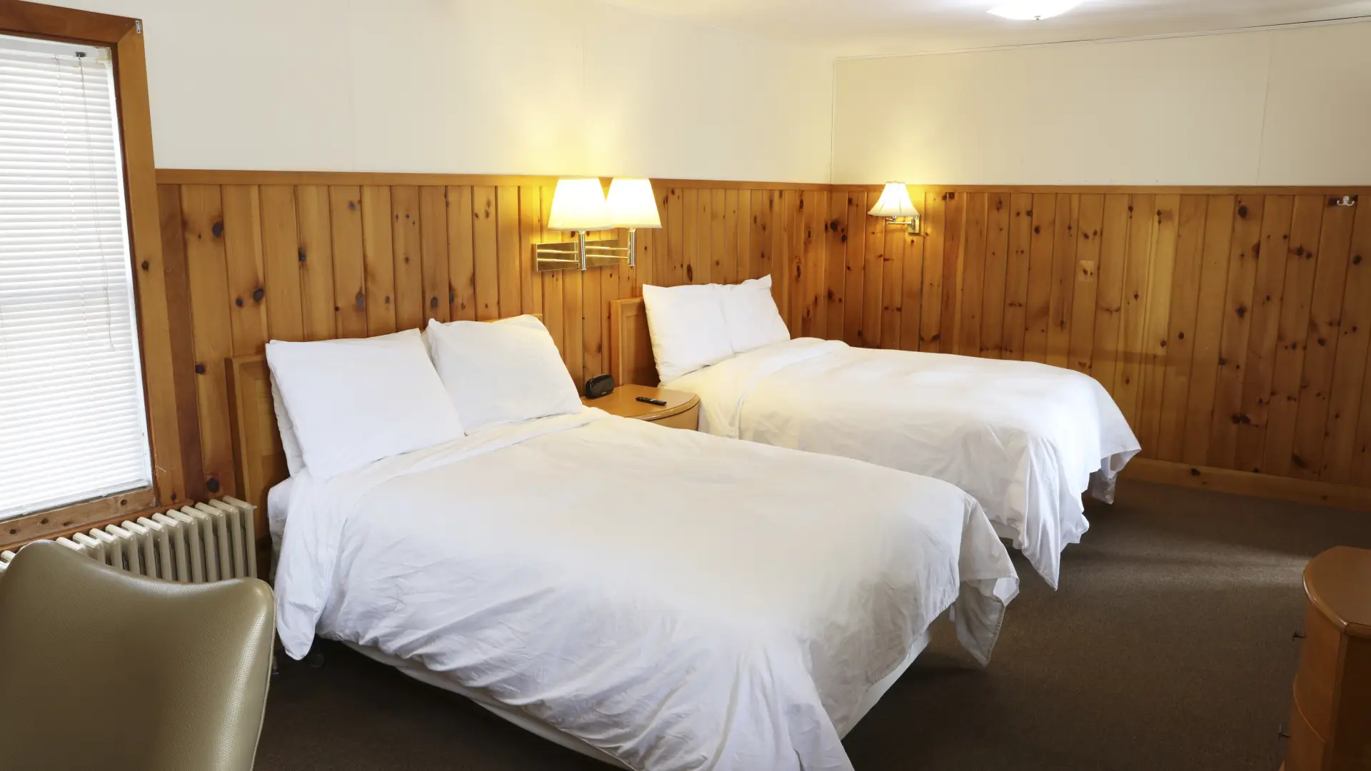 Plush white linens on two queen beds at The Ashley.