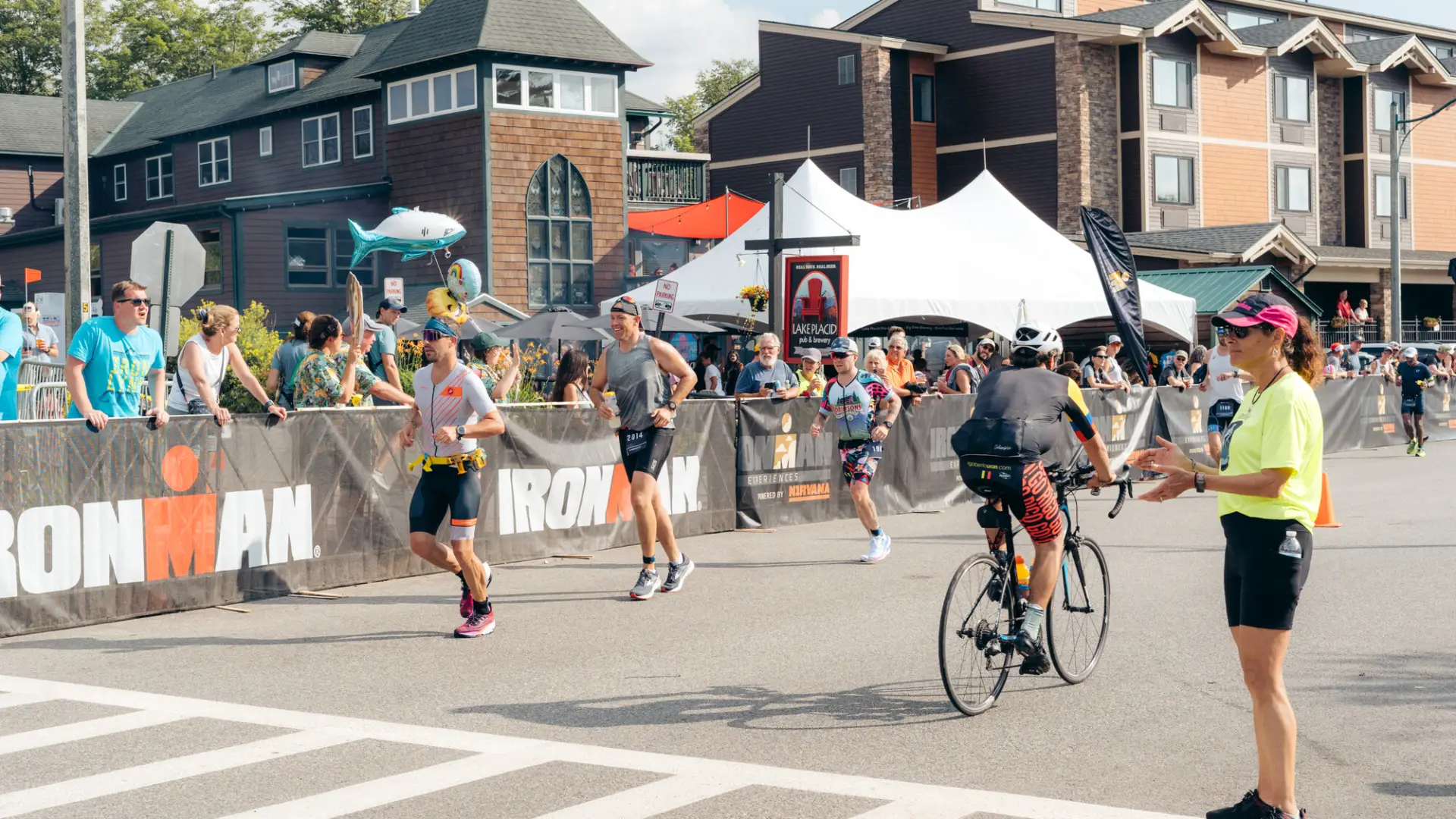 Ironman bikers and runners passing on the road