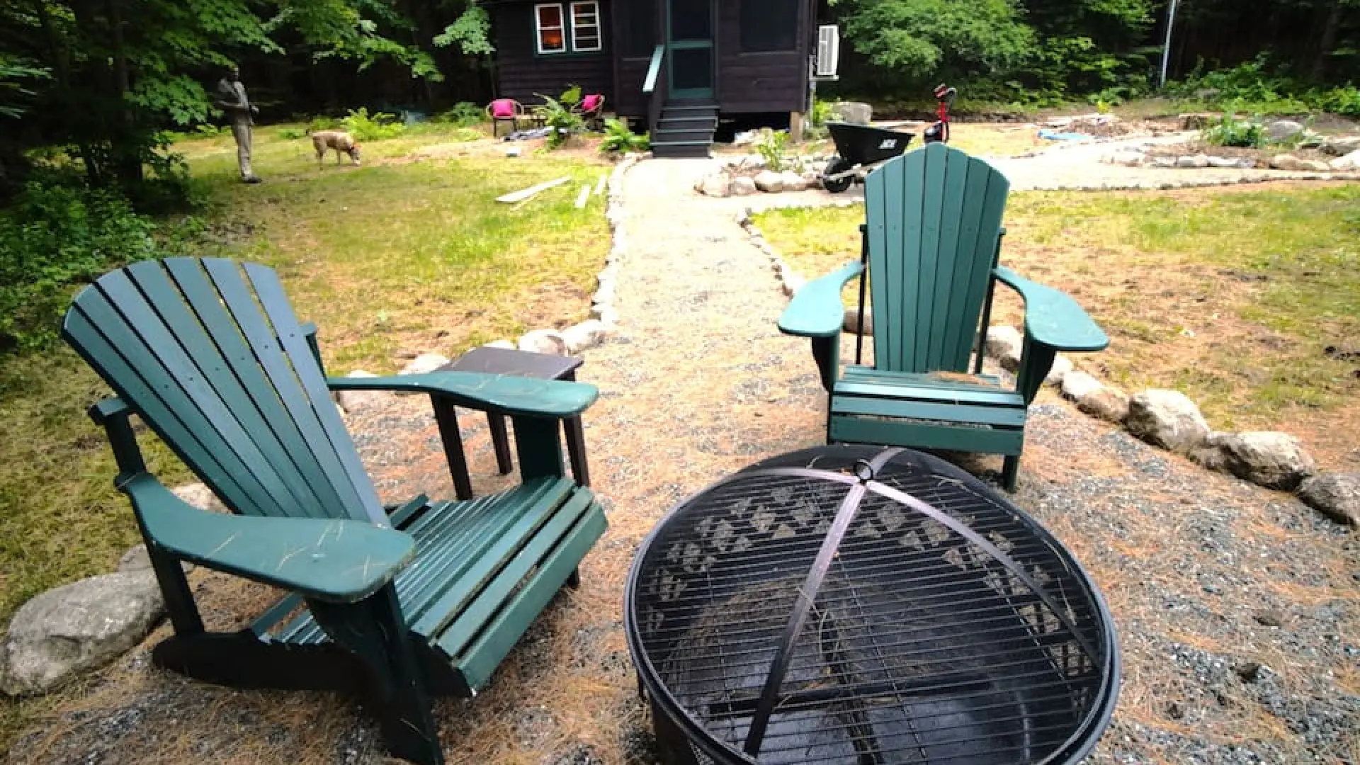 Outdoor fireplace and green adirondack chairs at Rockledge Cabins & Retreats 
