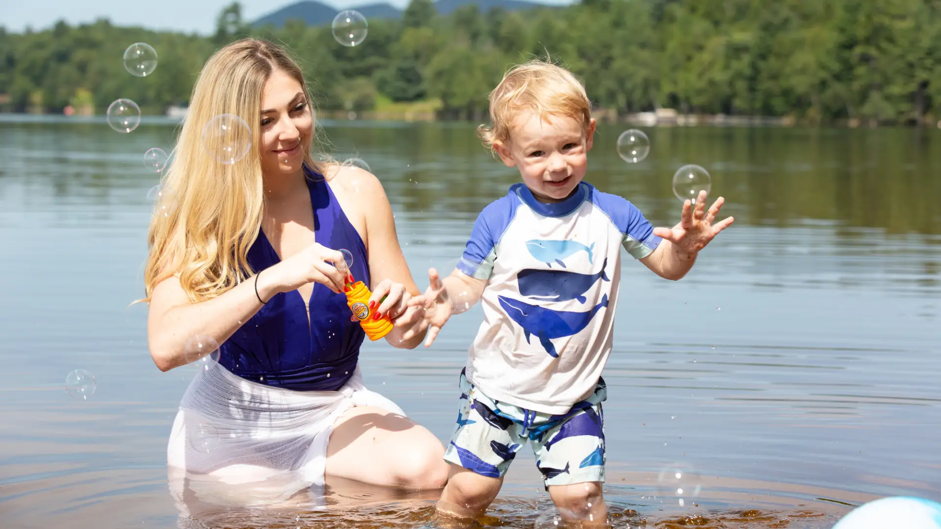 A mother and her child play in the water in Lake Clear