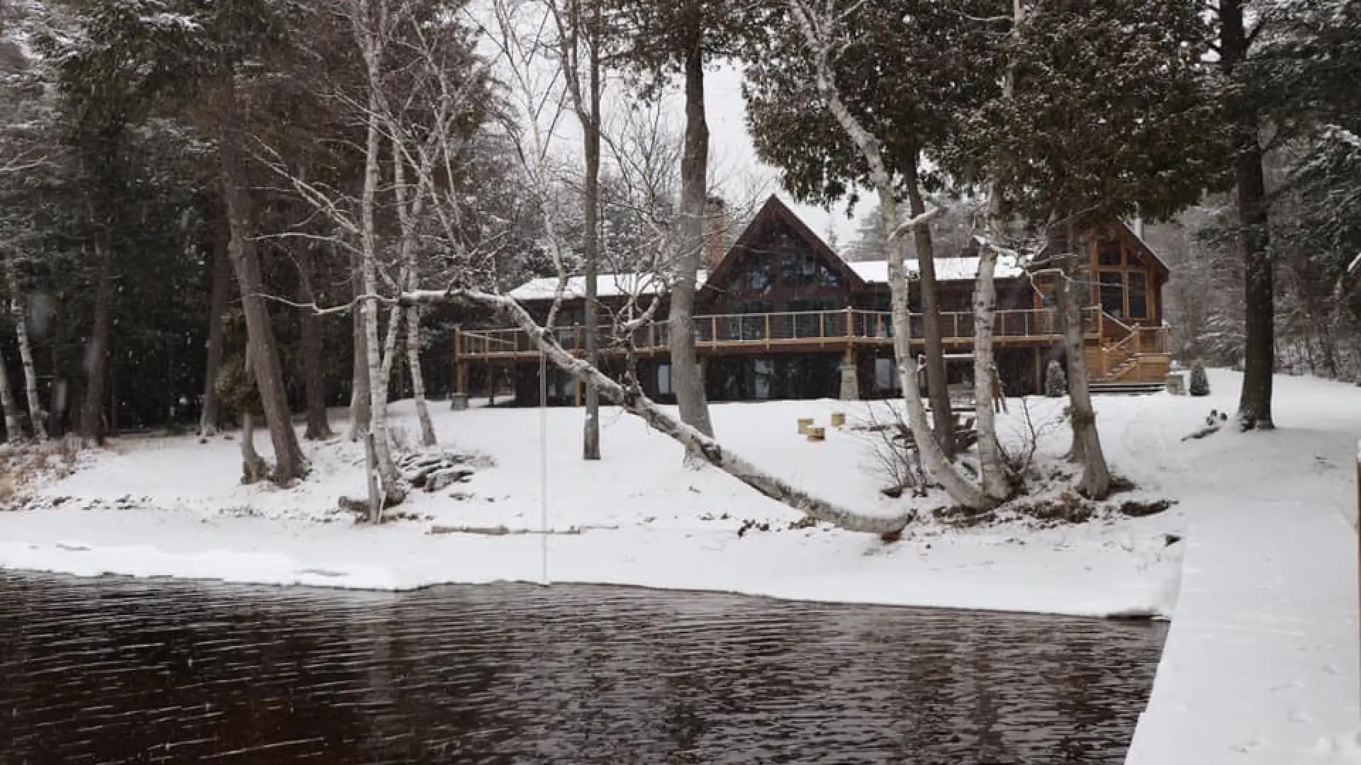 A winter scene at Alpenglow Lakeside Lodge showing the large lawn blanketed in snow.