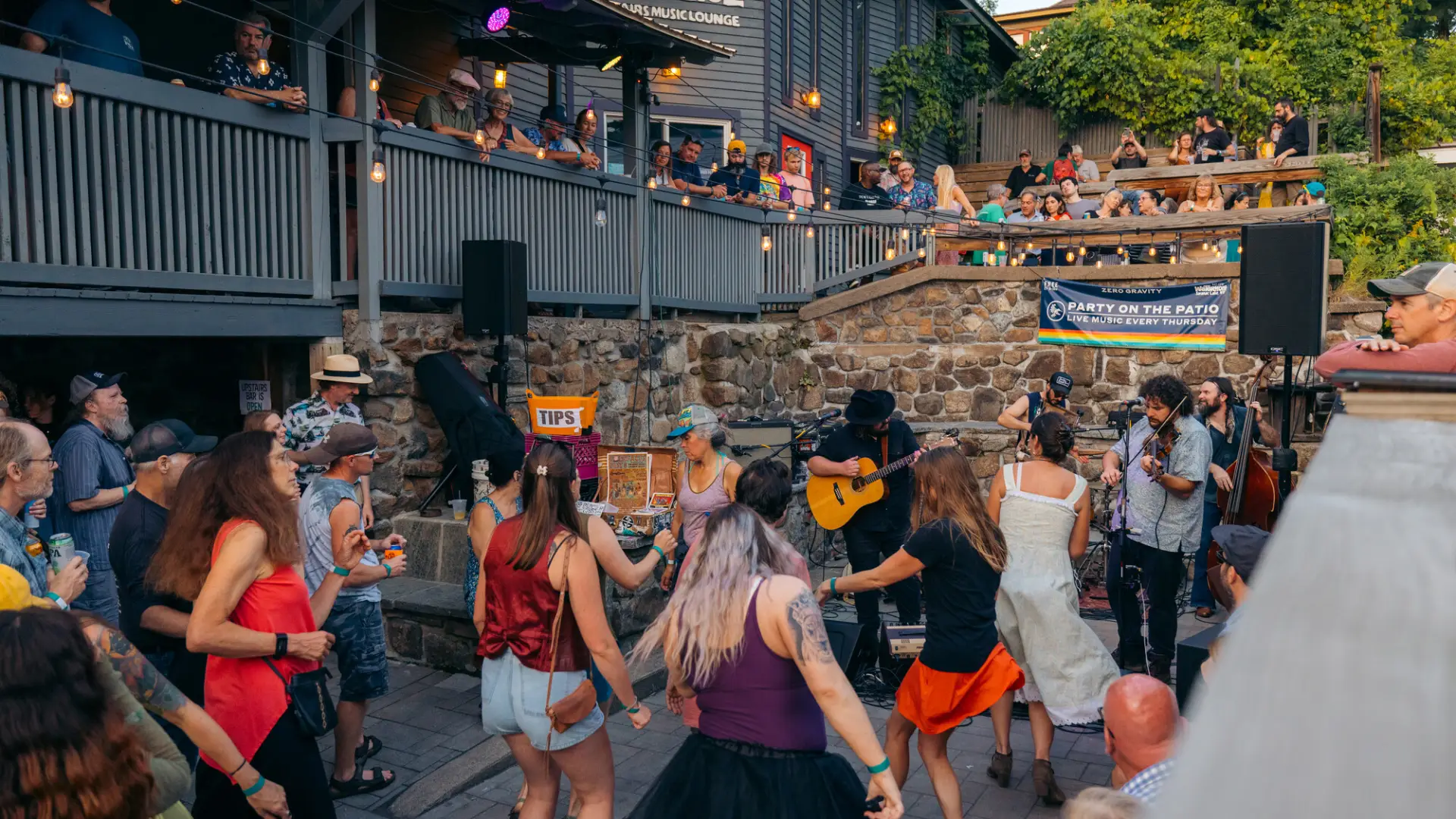People dance and party at an outdoor venue of a restaurant. 