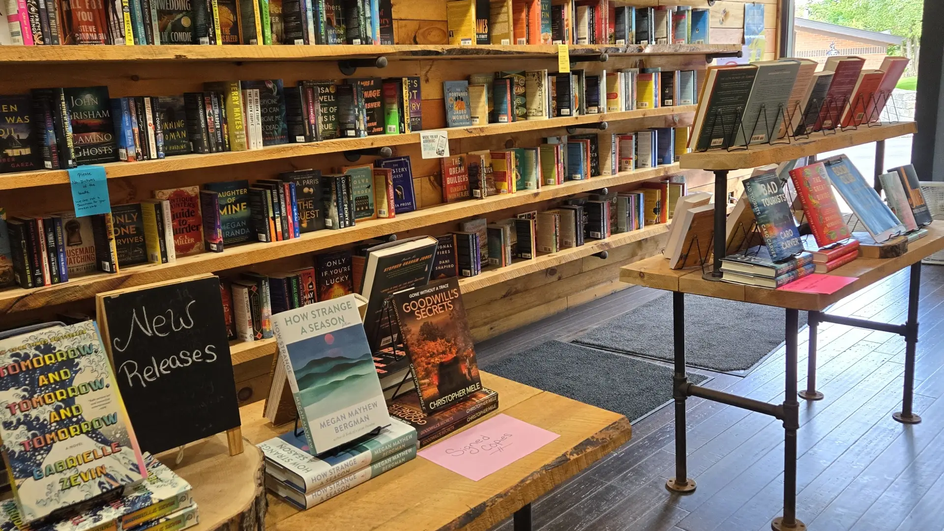 Walls and tables lined with Romance, Mystery, Fiction and Newly Released Books