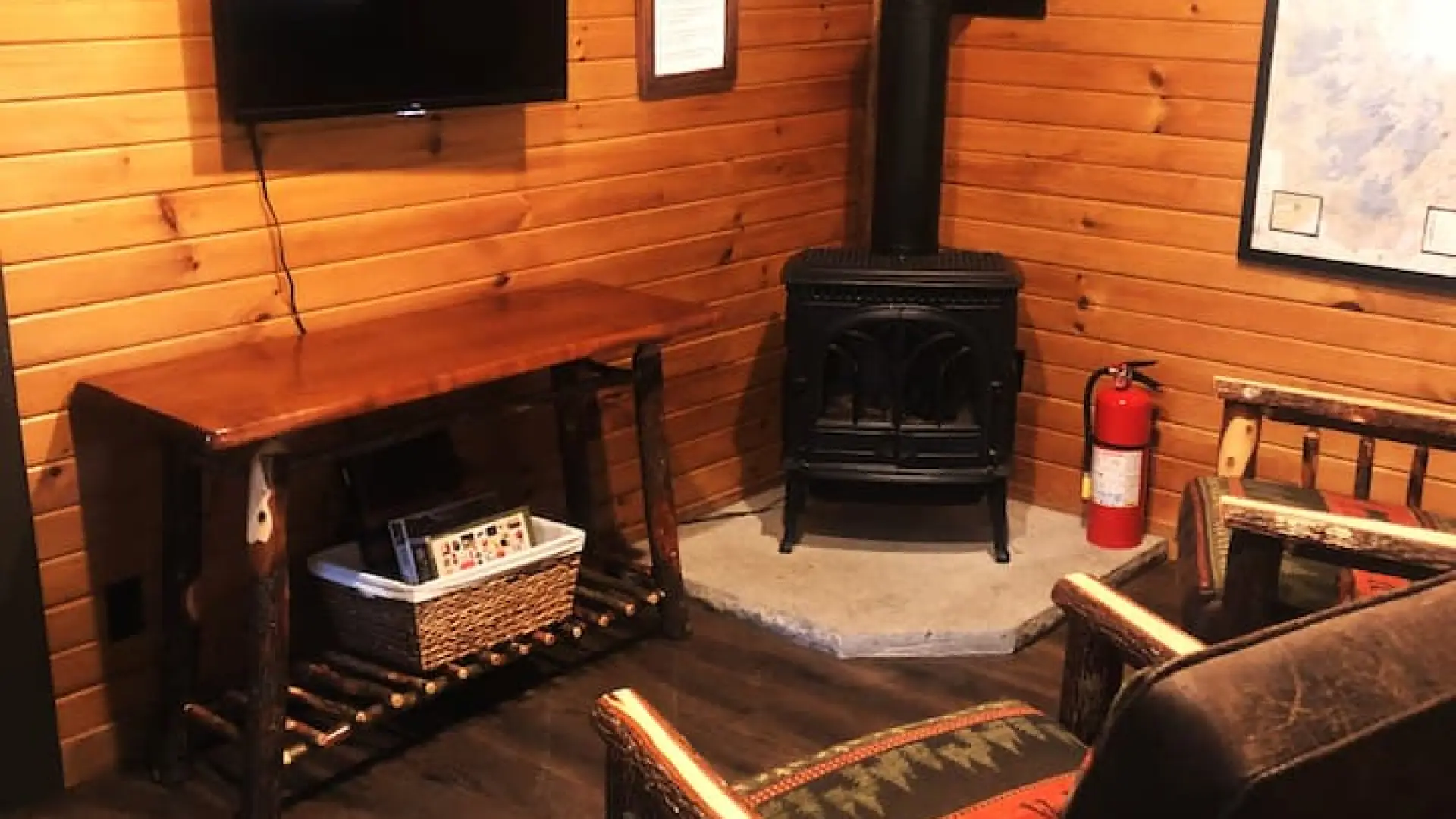 The living space with two rustic arm chairs, wood stove and tv at Rockledge Cabins & Retreats 
