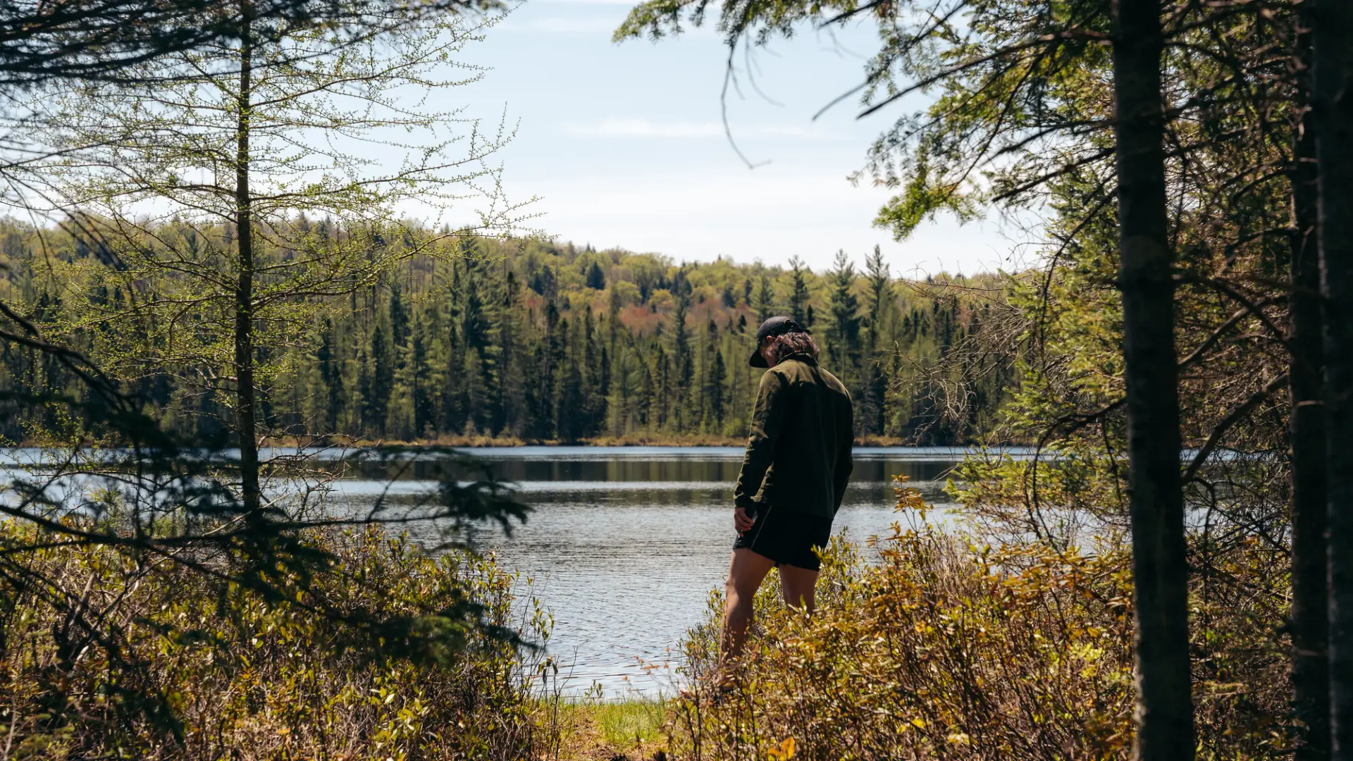 A hiker at a view of a small pond