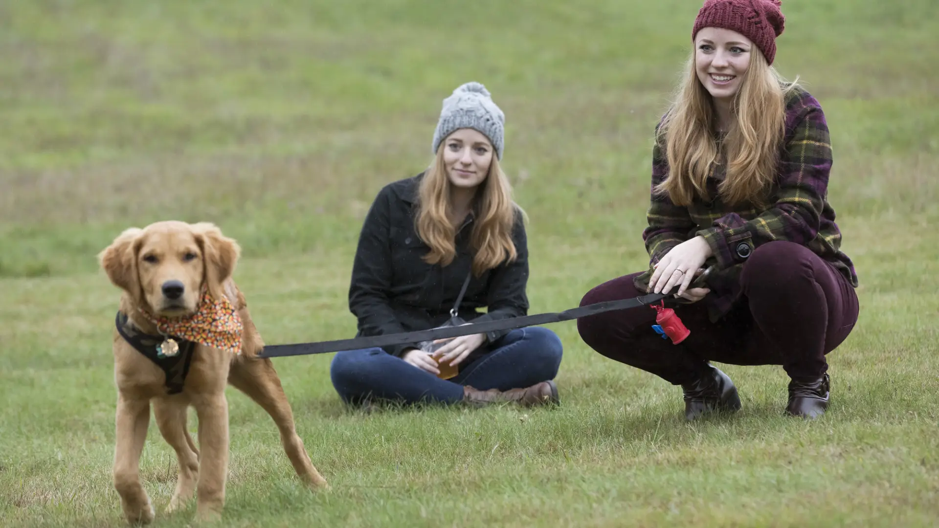 2 women with a golden puppy on leash