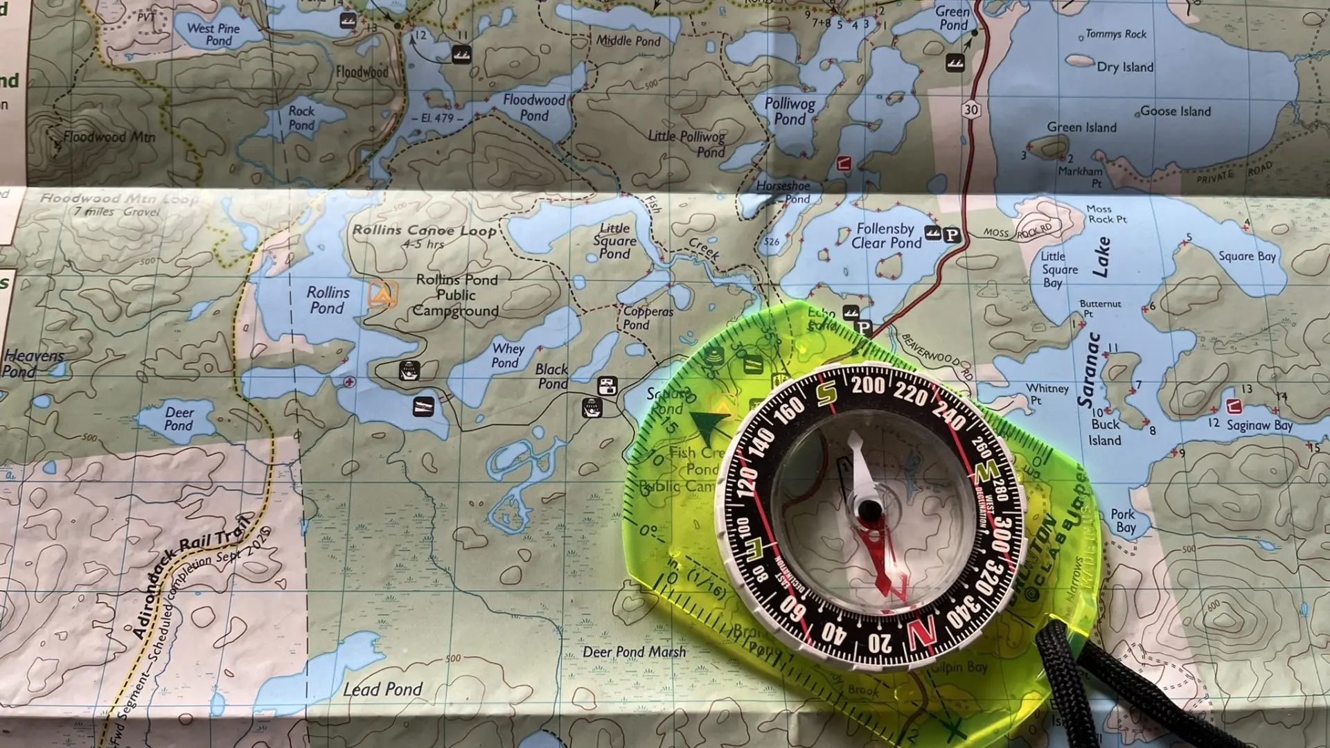 A map with a compass laying on top.