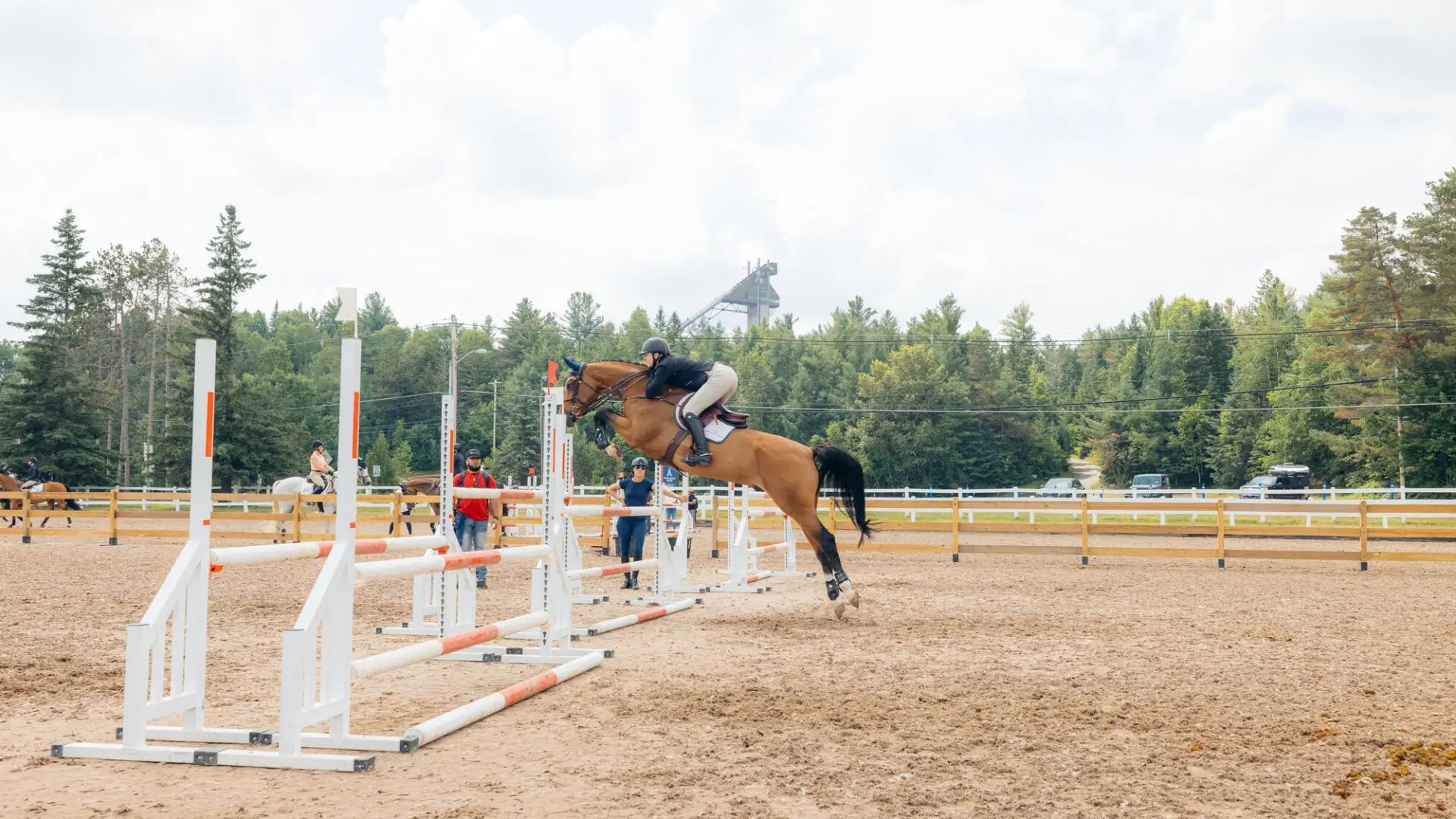 A horse and rider begin their jump over the bar