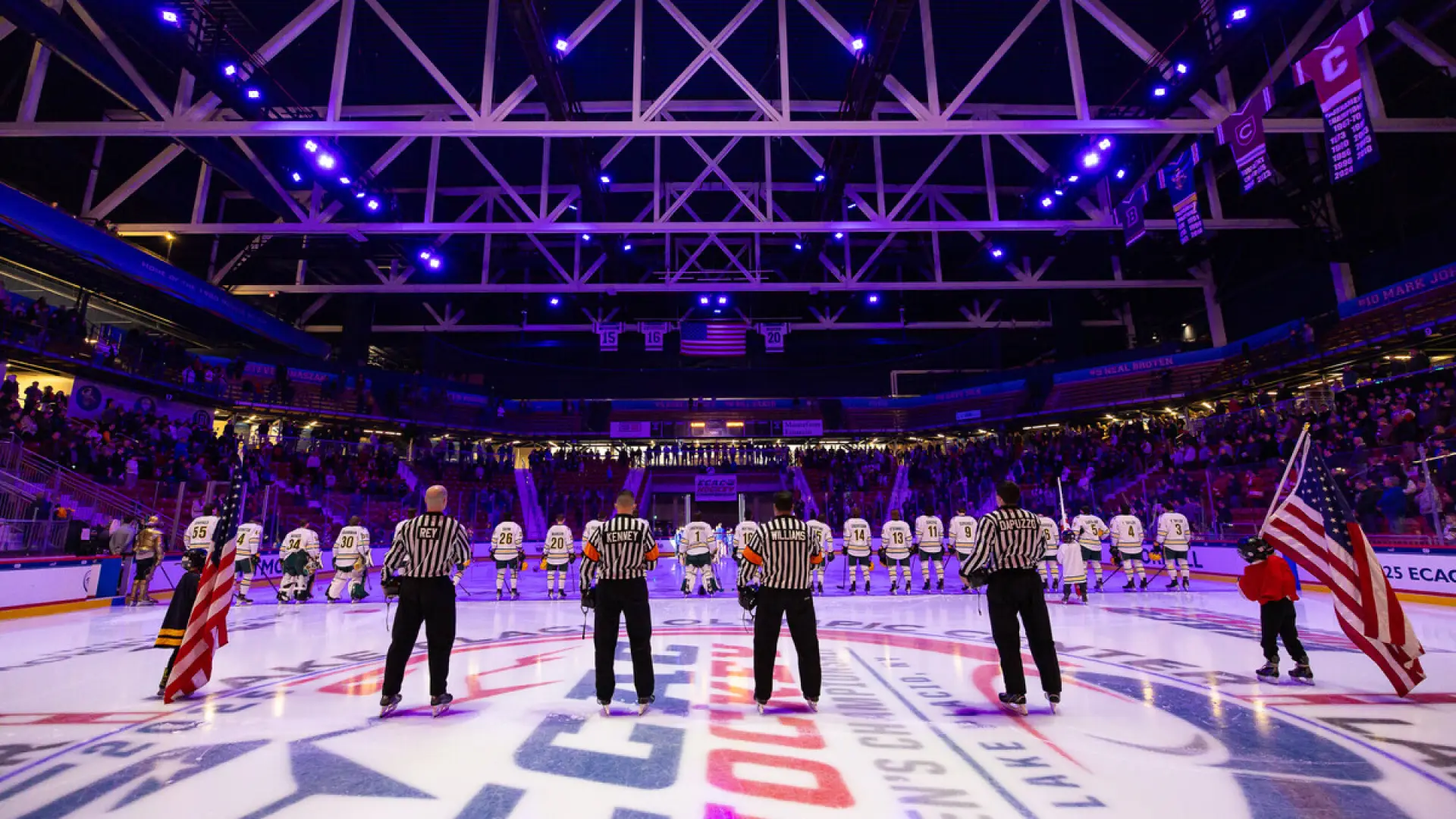 The image shows an indoor ice hockey arena filled with spectators. 