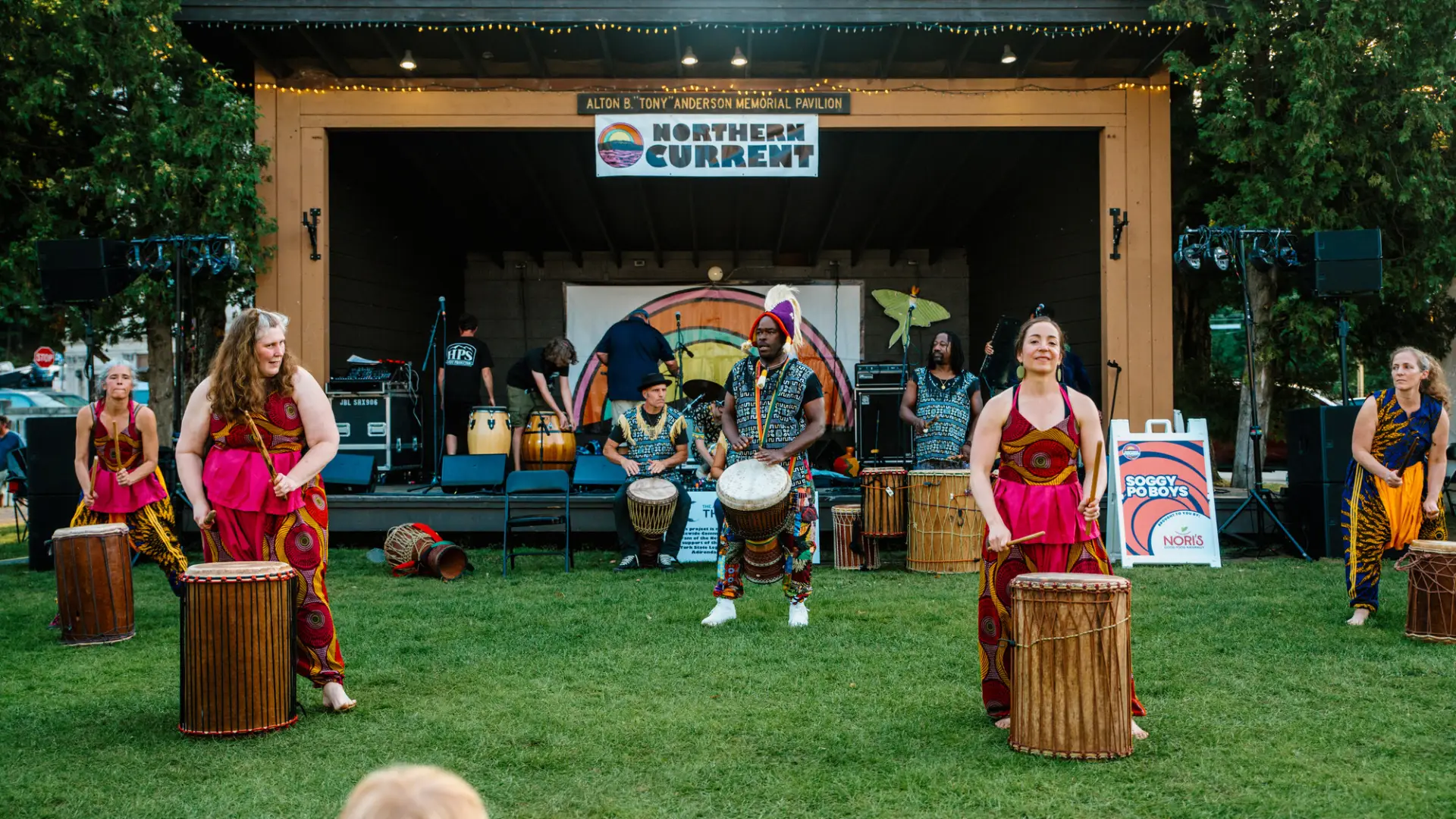 A circle of drums extends out past the stage into the grass