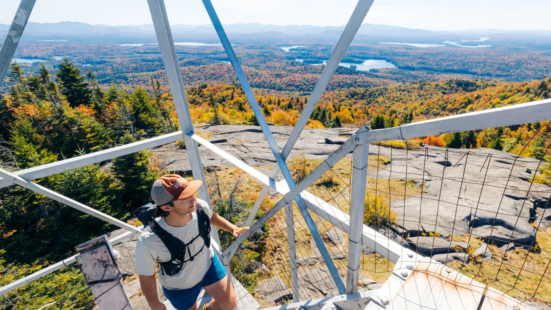 A hiker going up a fire tower in the fall