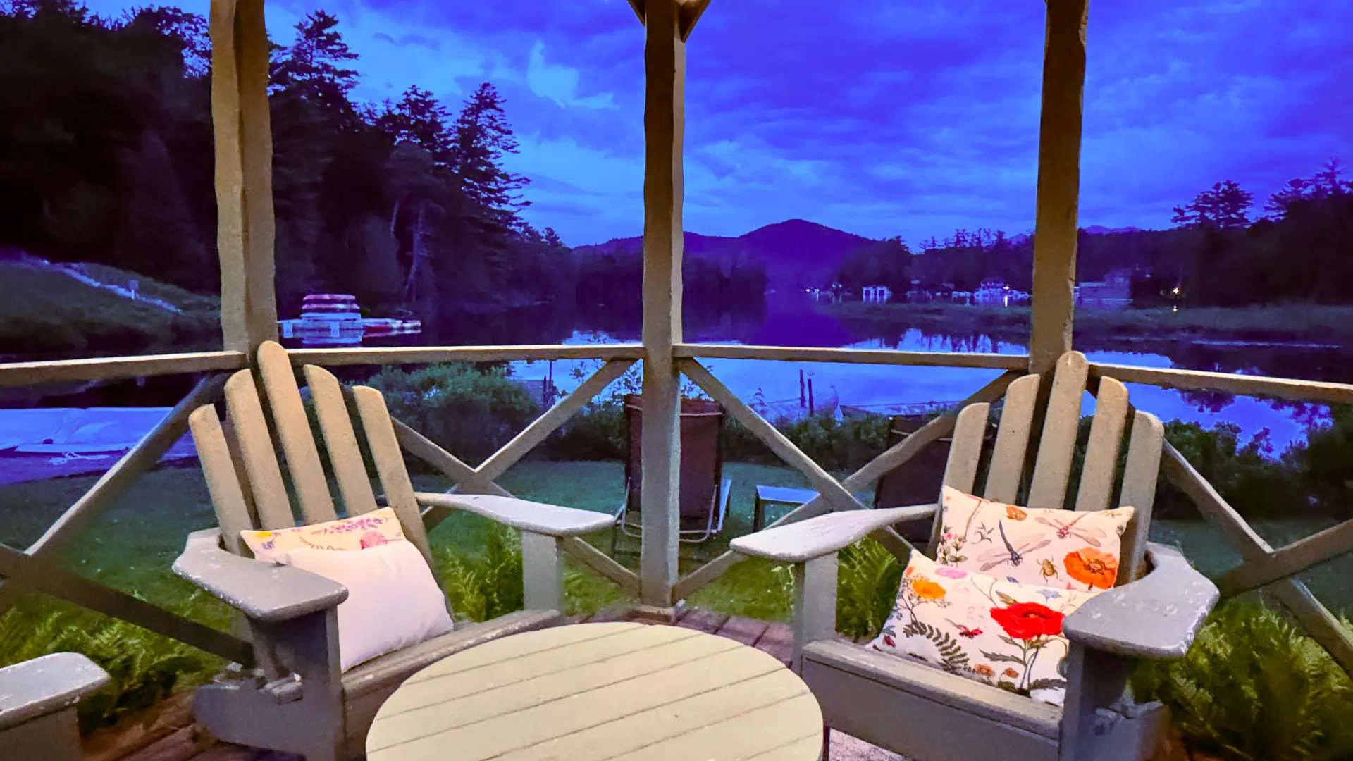 Adirondack chairs under the gazebo with string lights at dusk at Wildwood on the Lake.