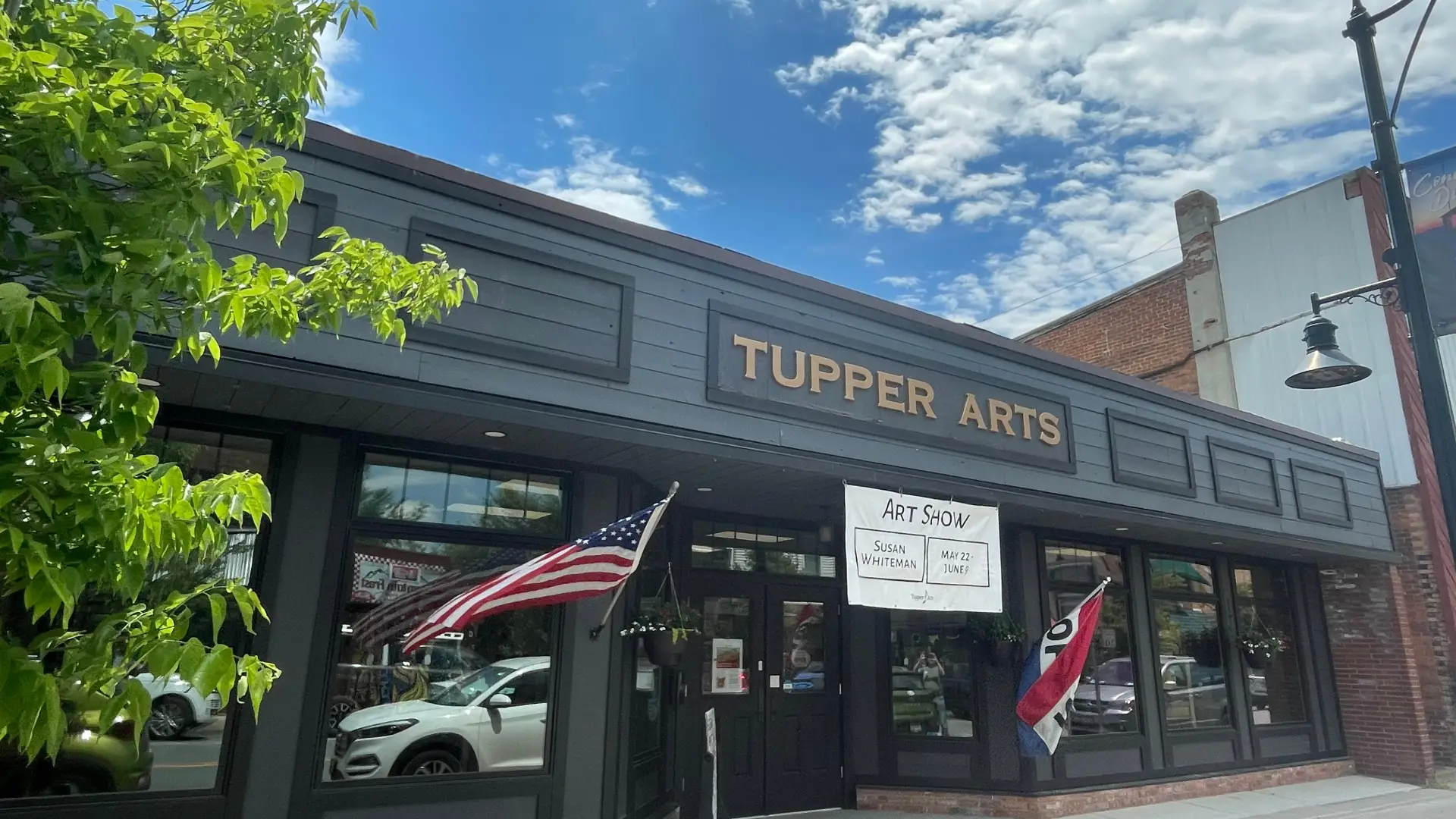 The exterior of Tupper Arts with blue skies and fluffy clouds above.
