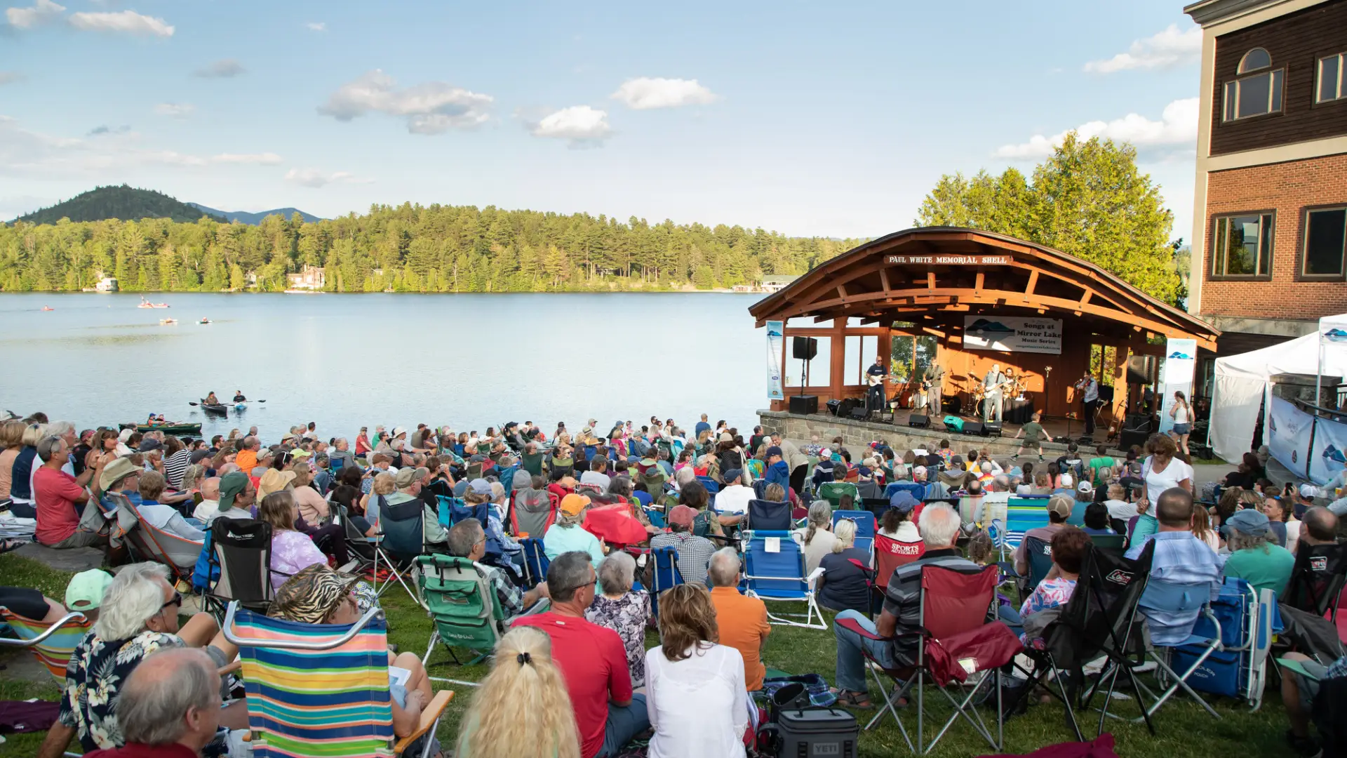 A crowd gathered in front of the band shell at Mid's Park, a hillside between Main Street and Mirror Lake in Lake Placid NY