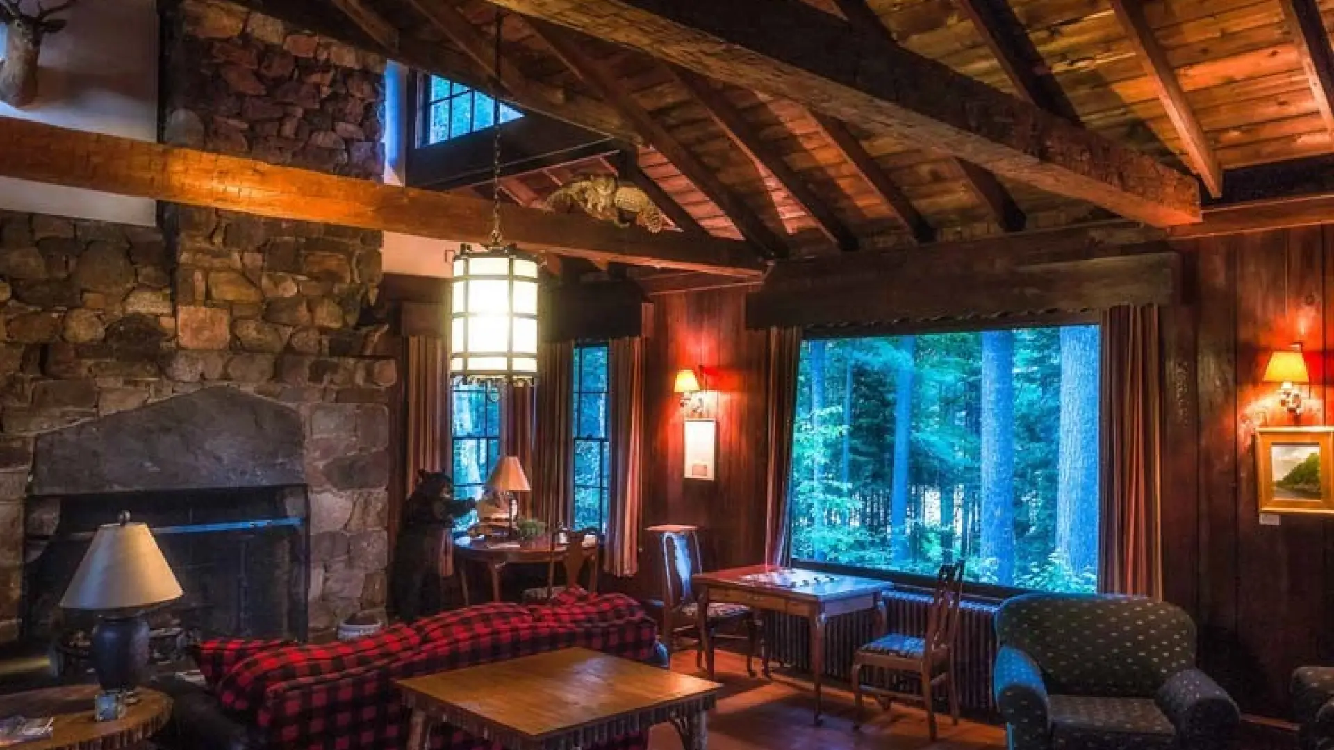 Rustic interior with high ceilings, rough beams and stone fireplace.