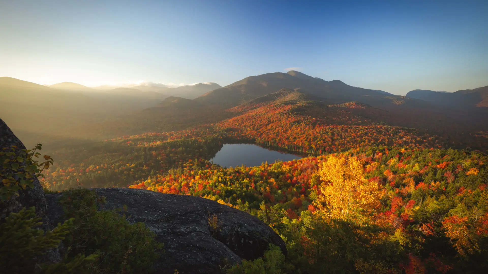 A small pond amongst tall mountains in the fall