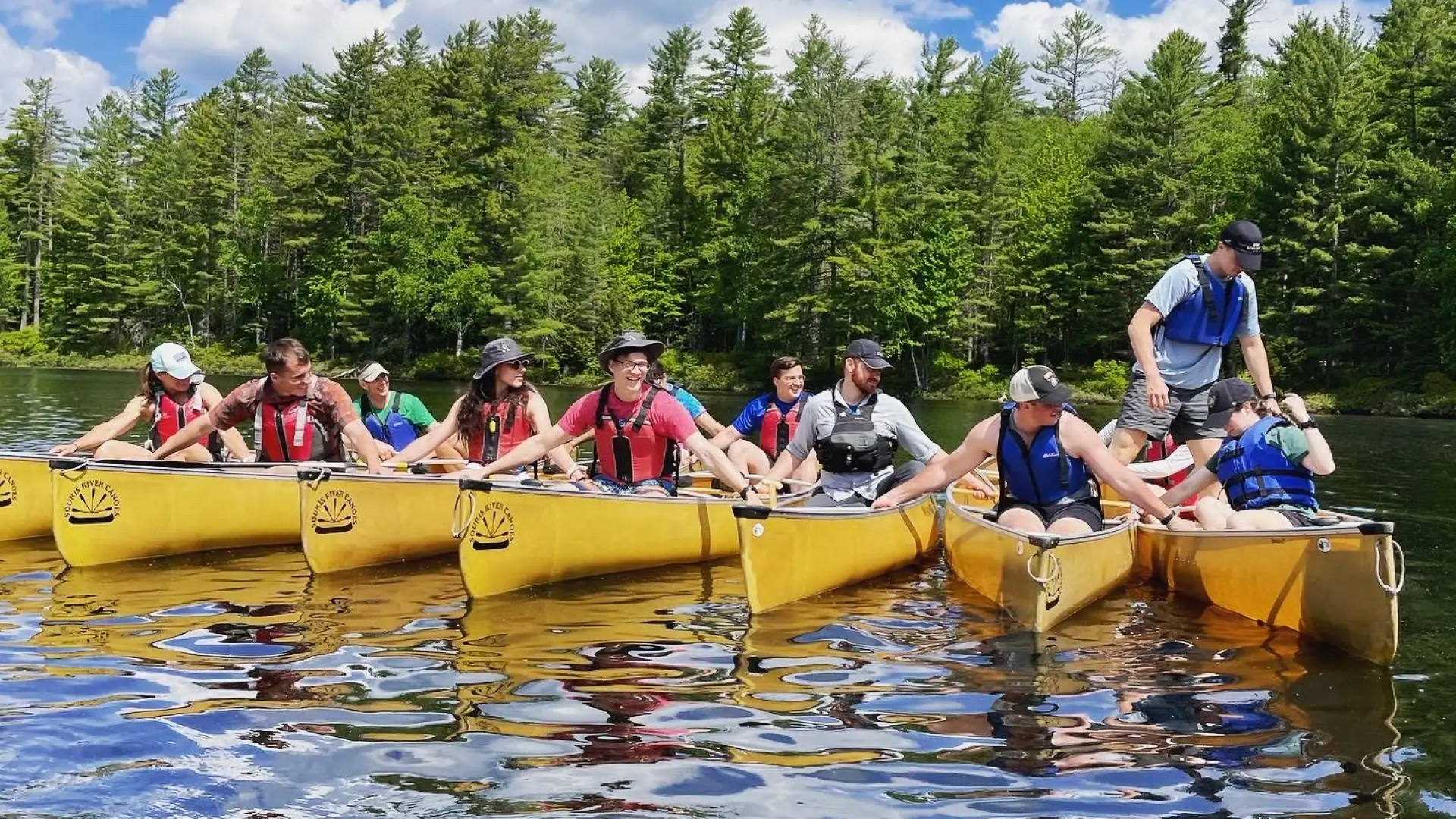 A group of paddlers lined up on the water.