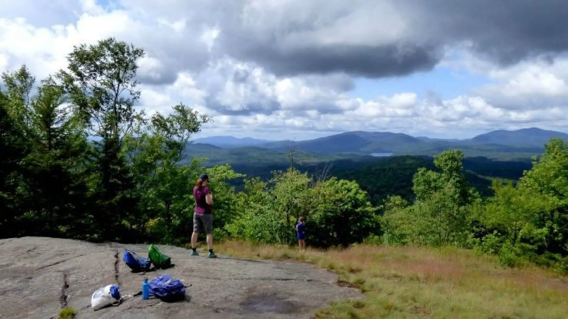 A hiker stands on partially open summit