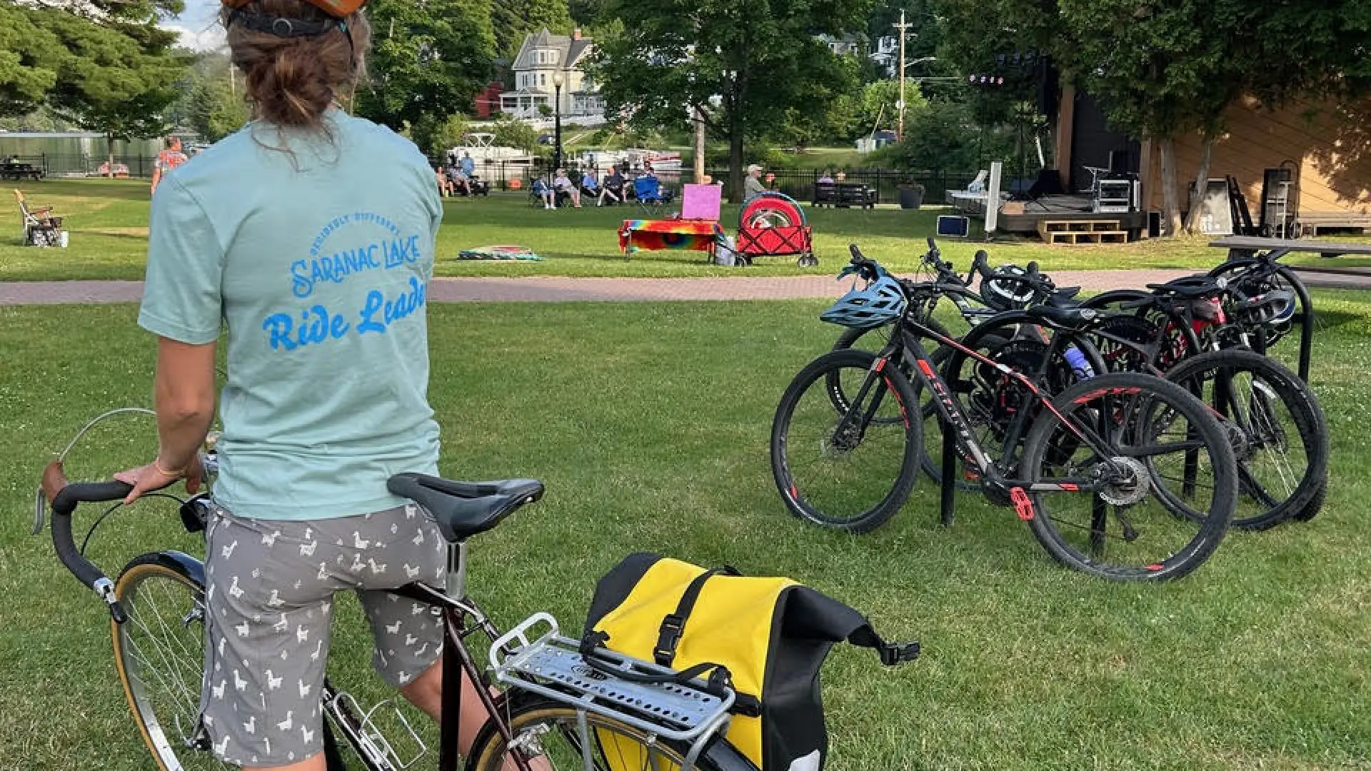 the back of a person on a bicycle at a park with other bikes parked nearby