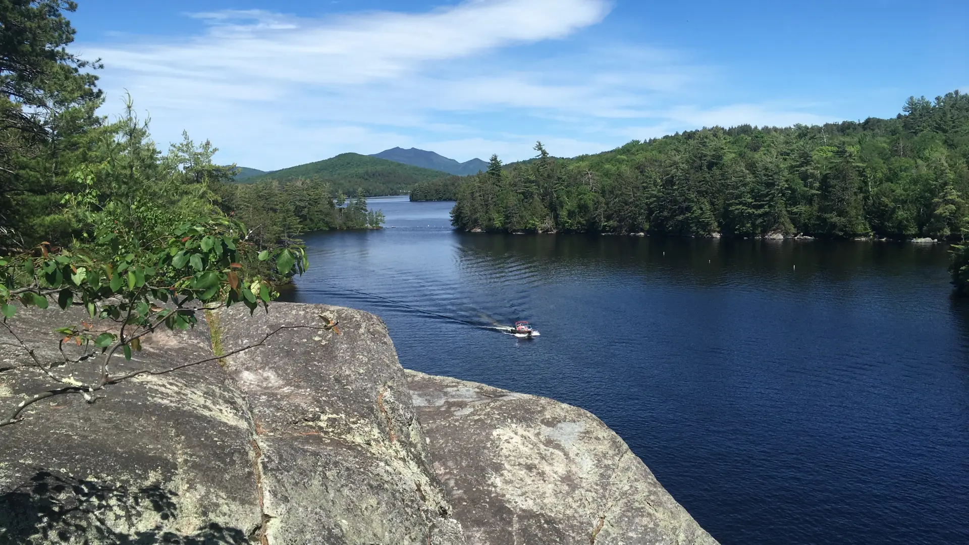 View of a motorboat from the shore of Lower Saranac Lake