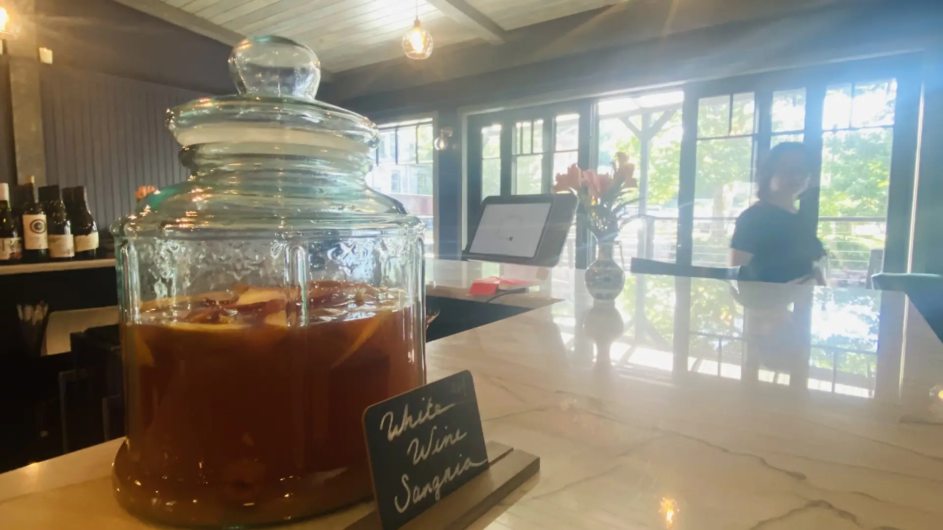 Sangria sitting in a large glass jar on top of the granite counter of the bar