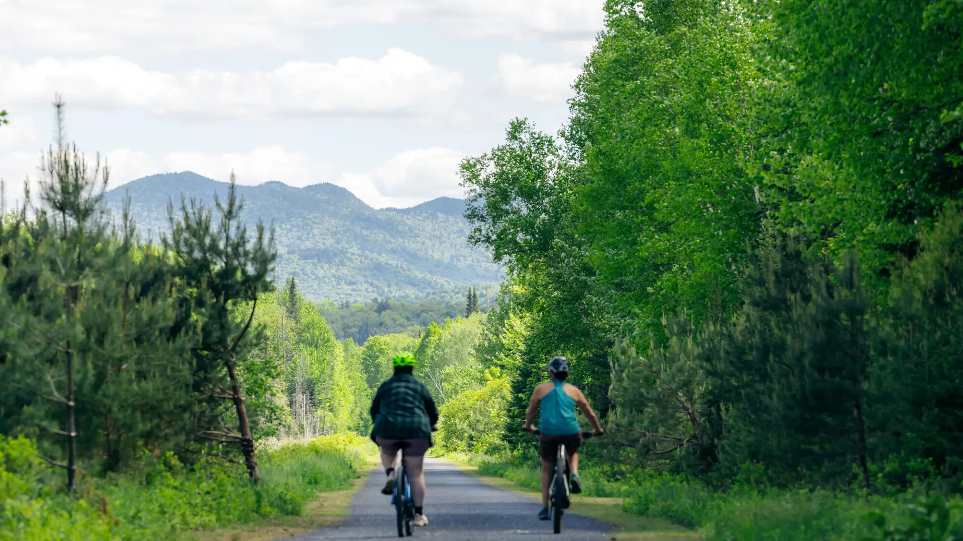 Two people cycle on a rail trail