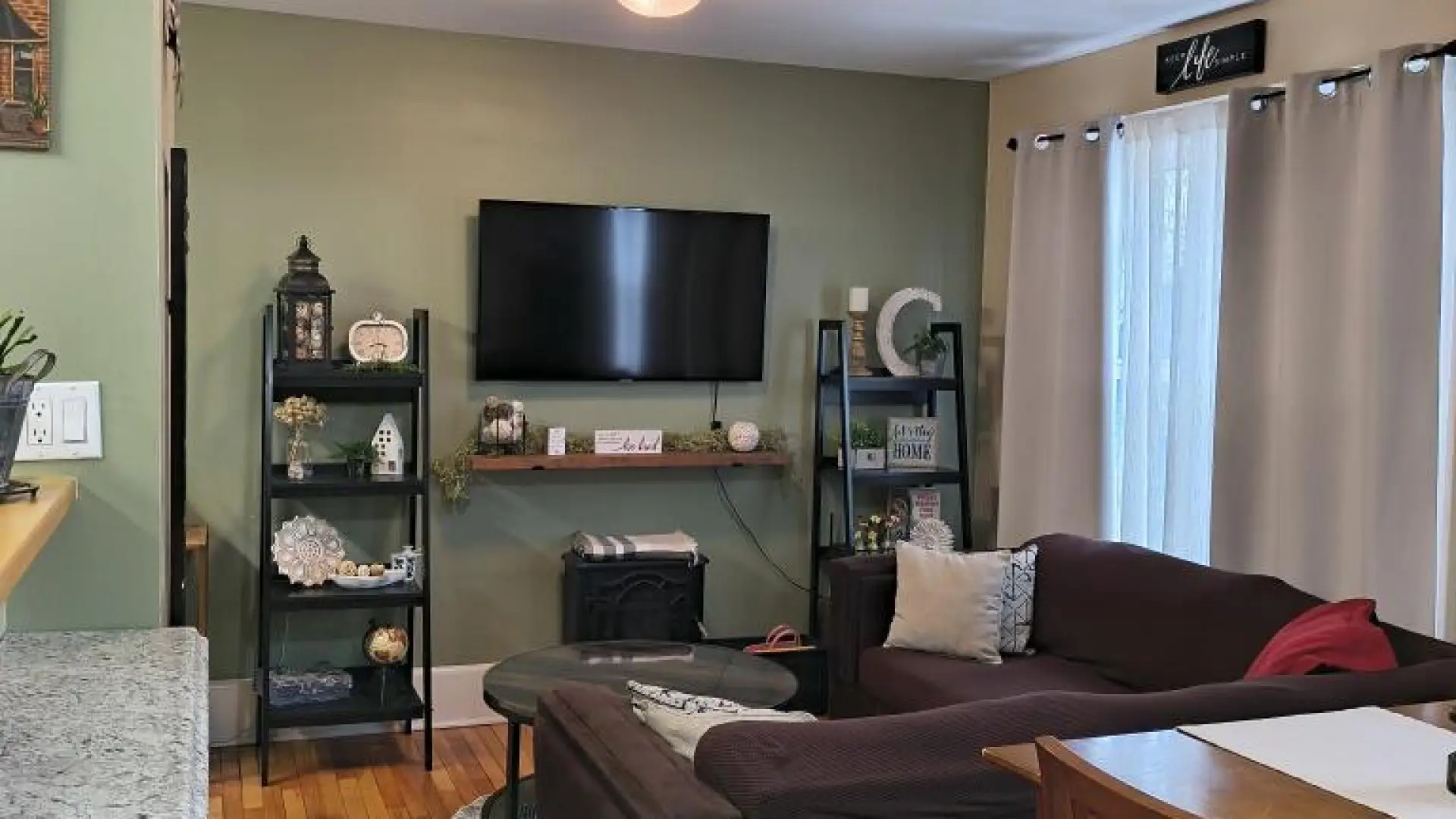 A green living room with wood floors and trim.