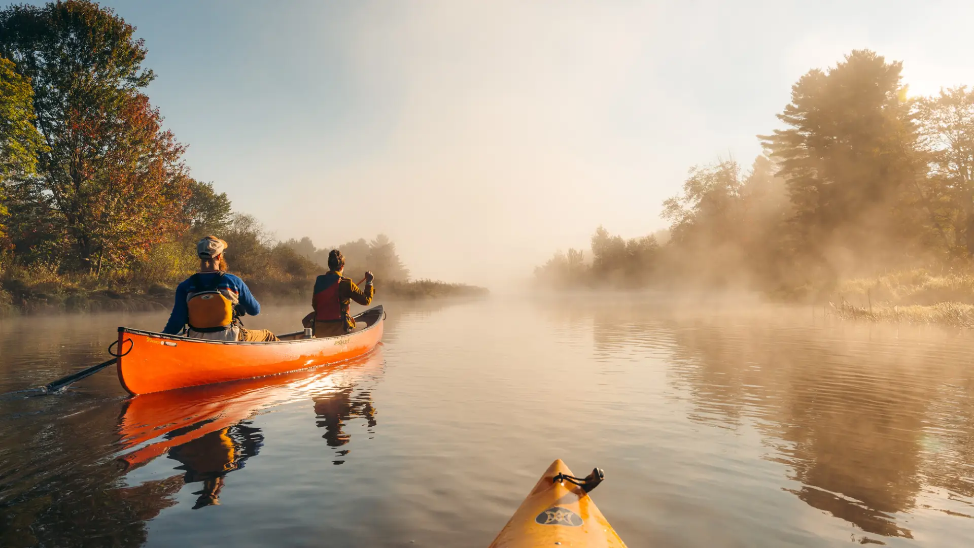 A few canoers on the Saranac River during sunrise