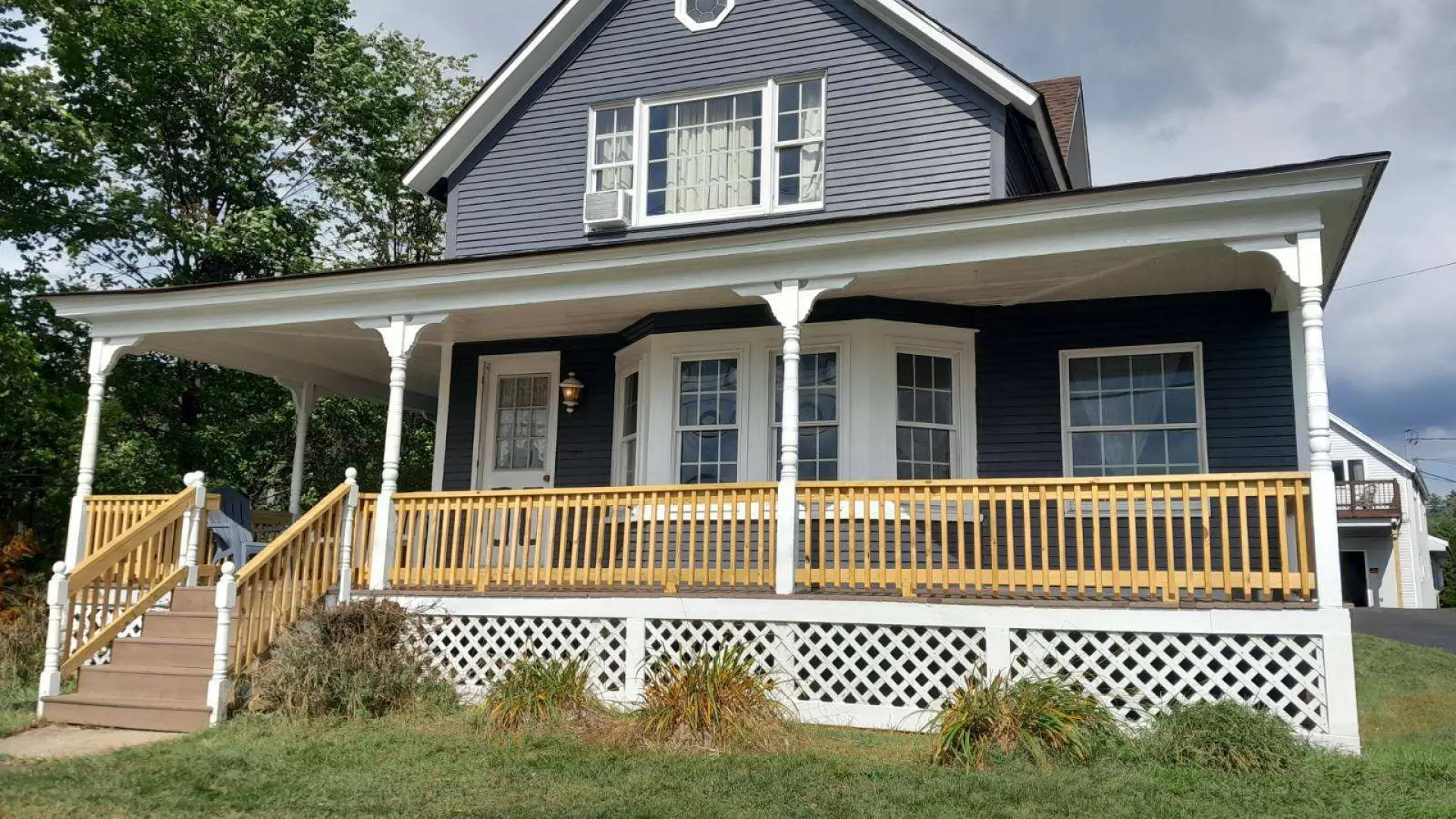 A blue house with white trim at the Sara Placid Inn & Suites.