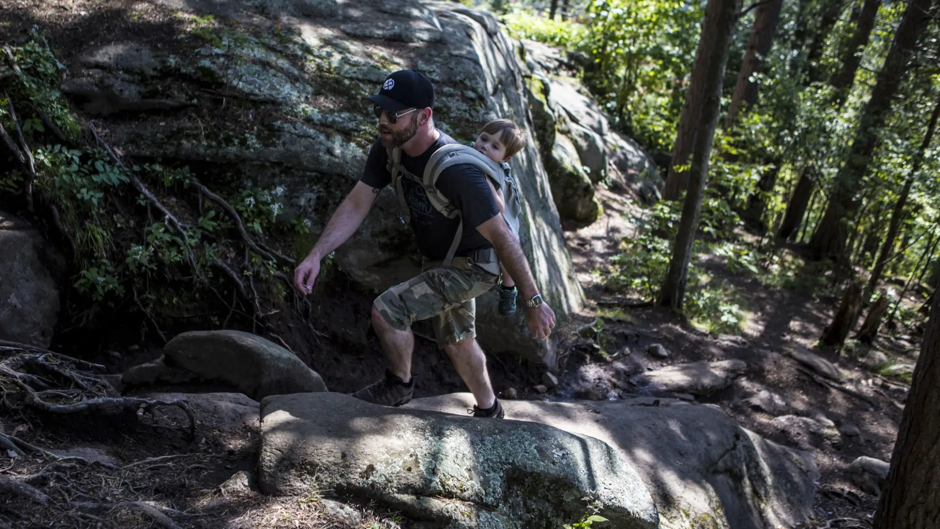 A man ascends a rocky part of the trail to the top of Baker Mountain