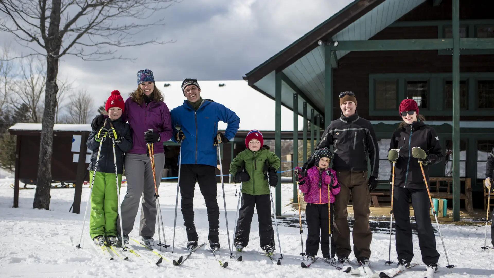 Two happy families pose for a photo in front of the Dewey Mountain Lodge