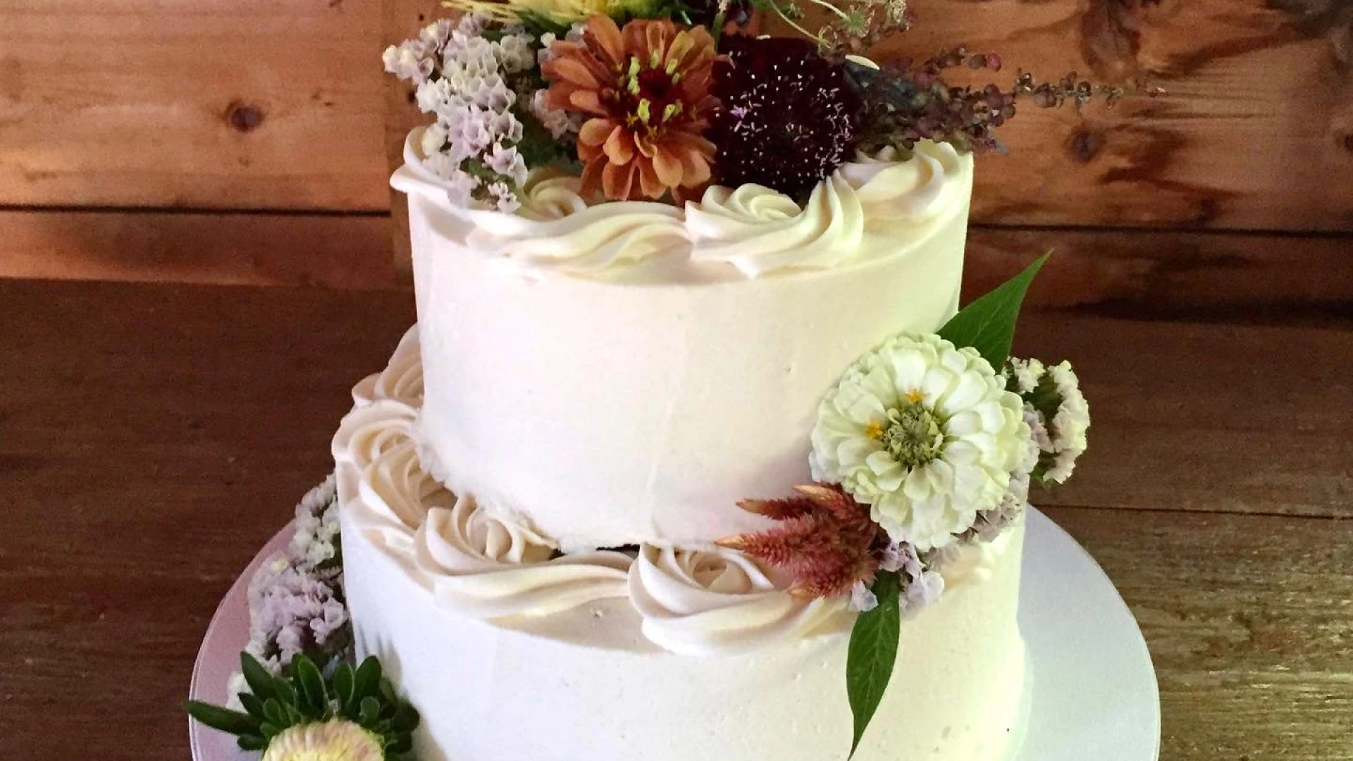 A two tiered cake with autumnal flowers 