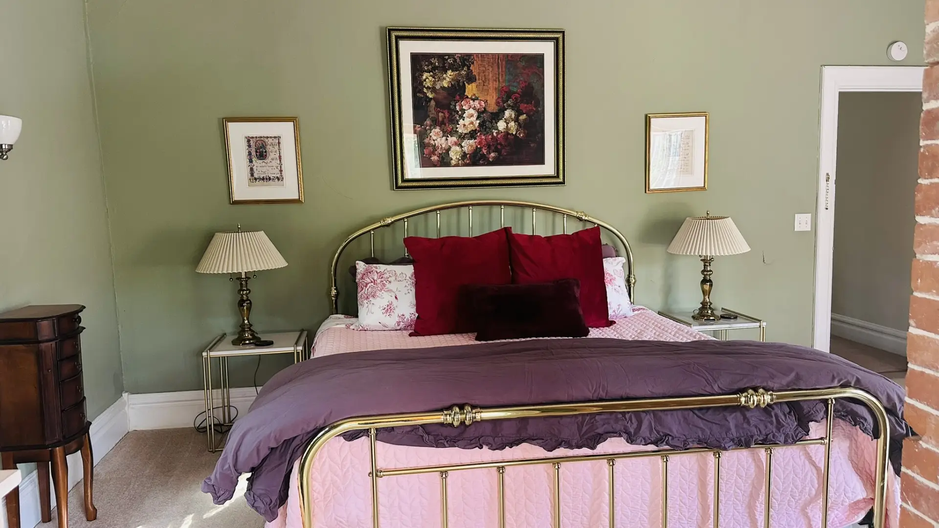 Olive green walls and gold metal bed frame transport you back in time