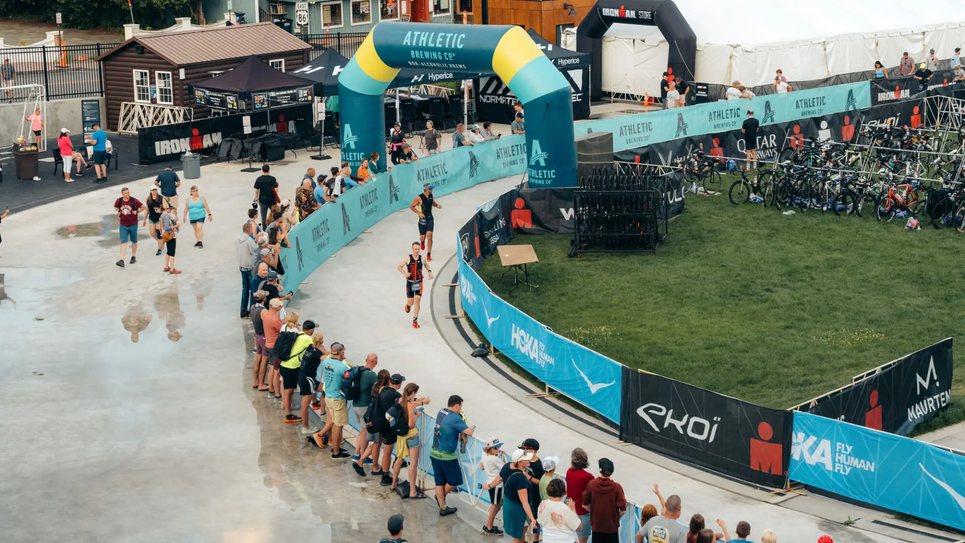 Ironman athletes running on oval with spectators watching
