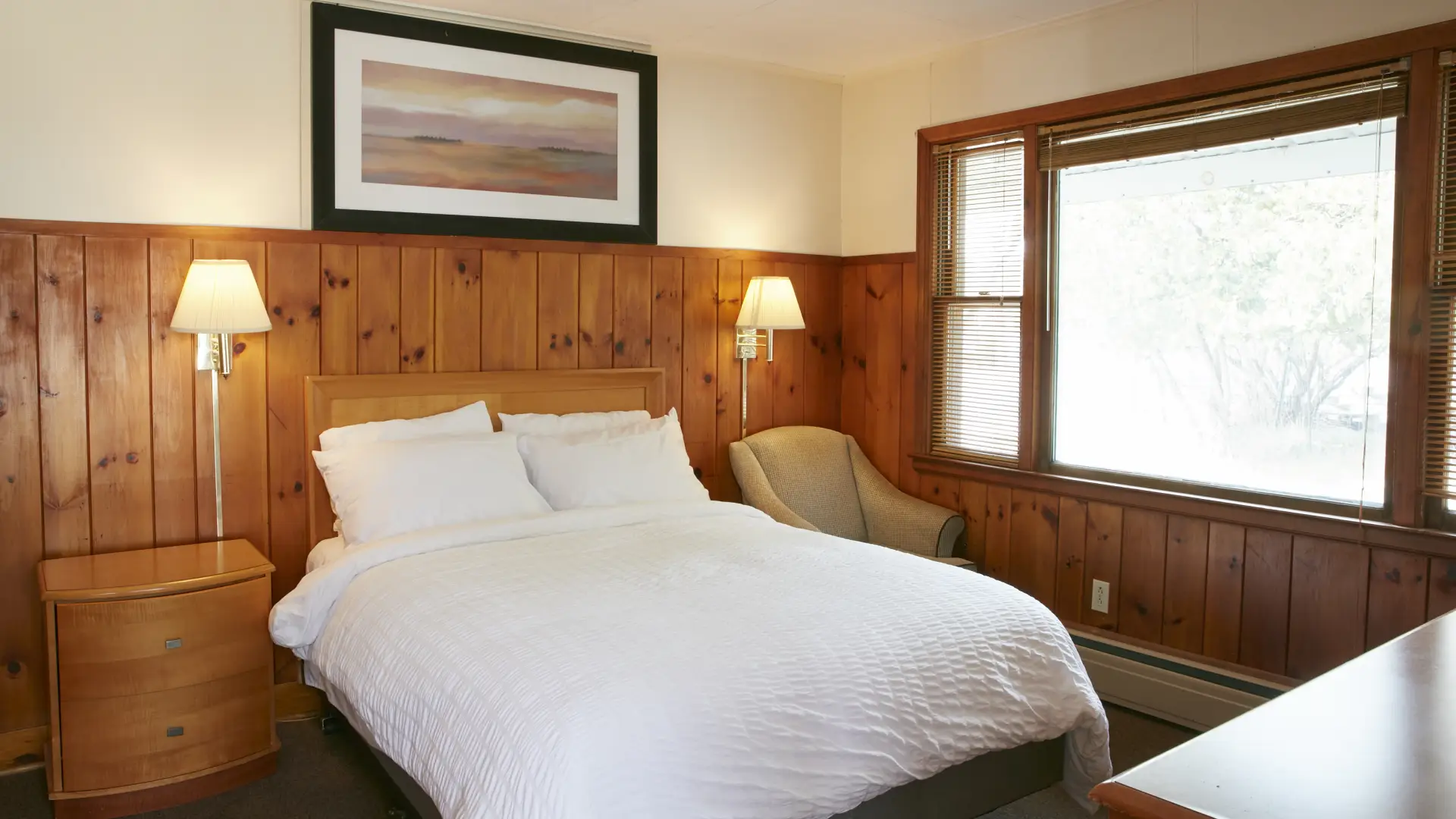 Plush white linens on a king bed at The Ashley.