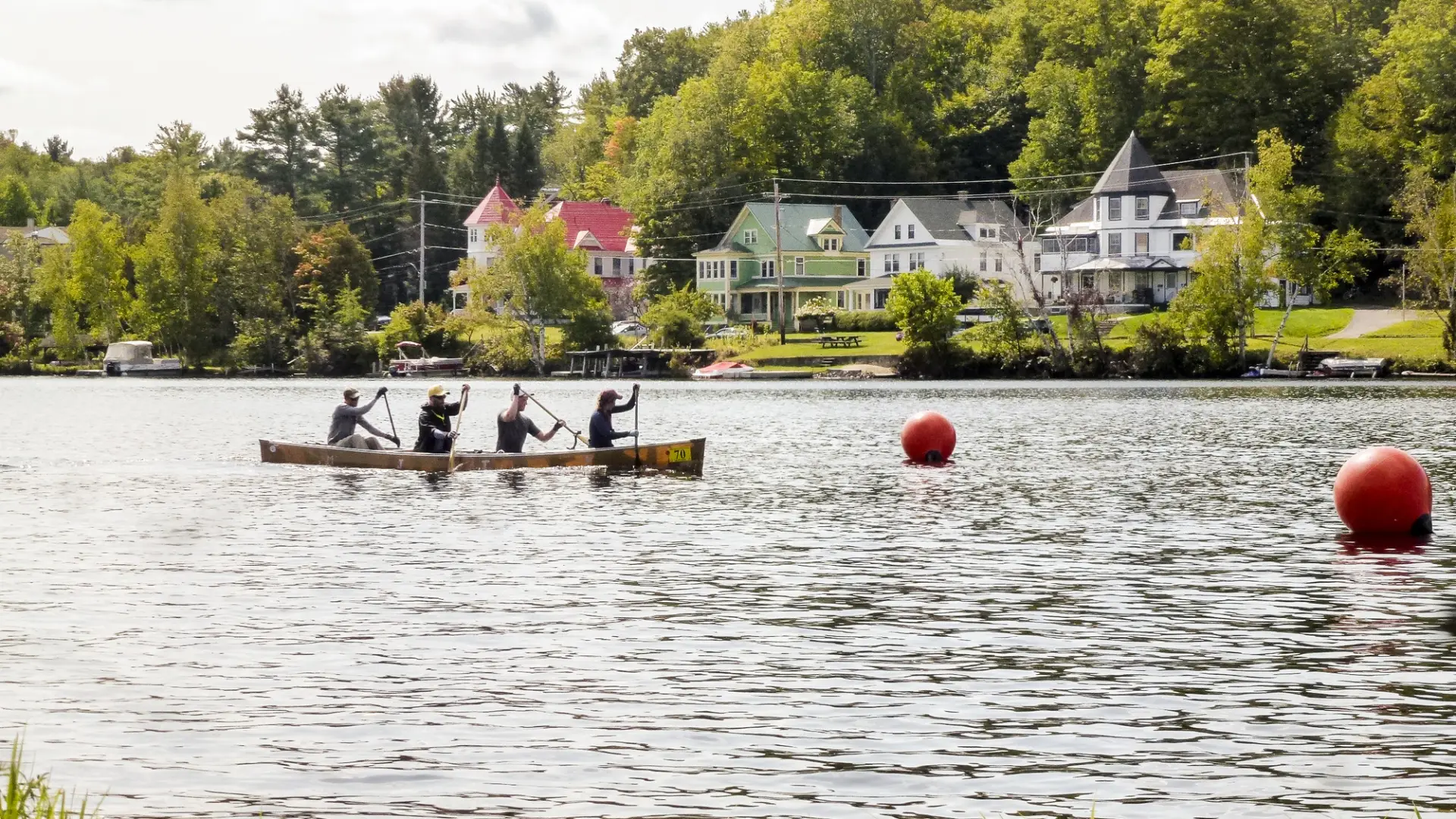 A team of four paddle a canoe down a river