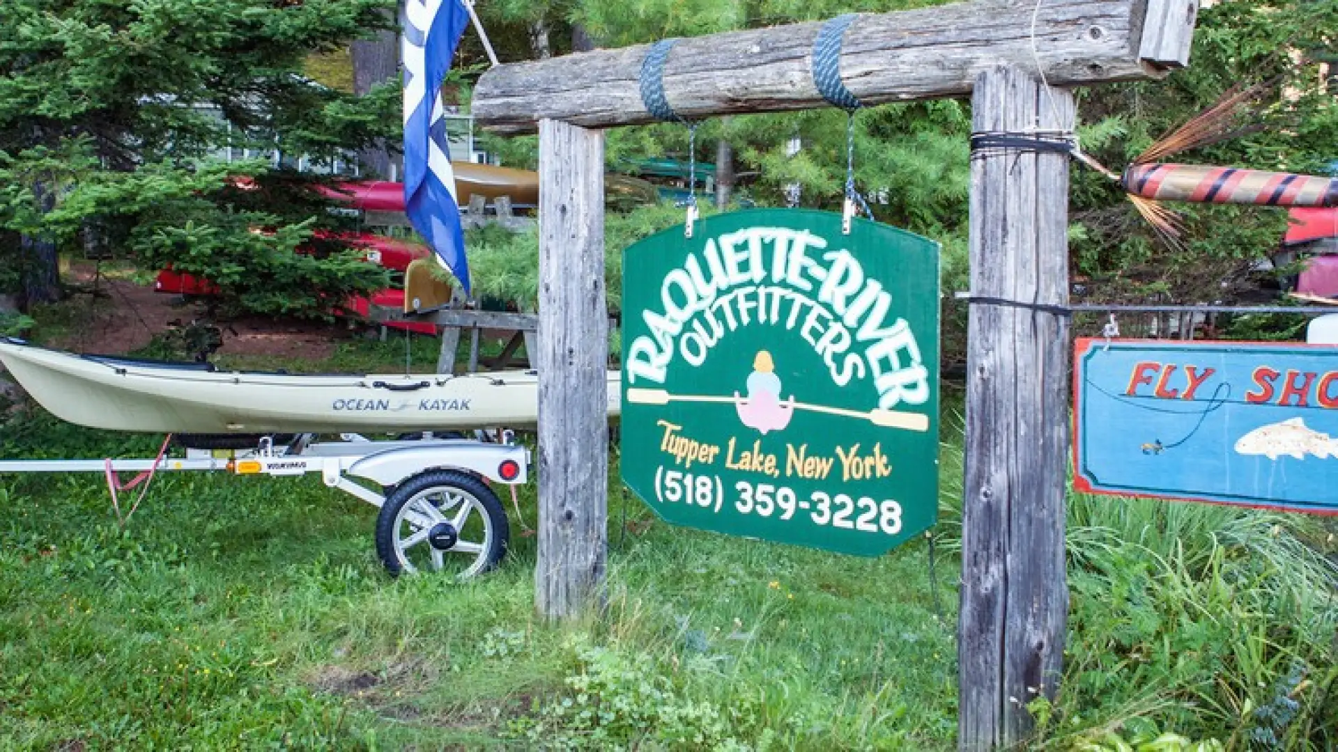 The green sign for Raquette River Outfitters