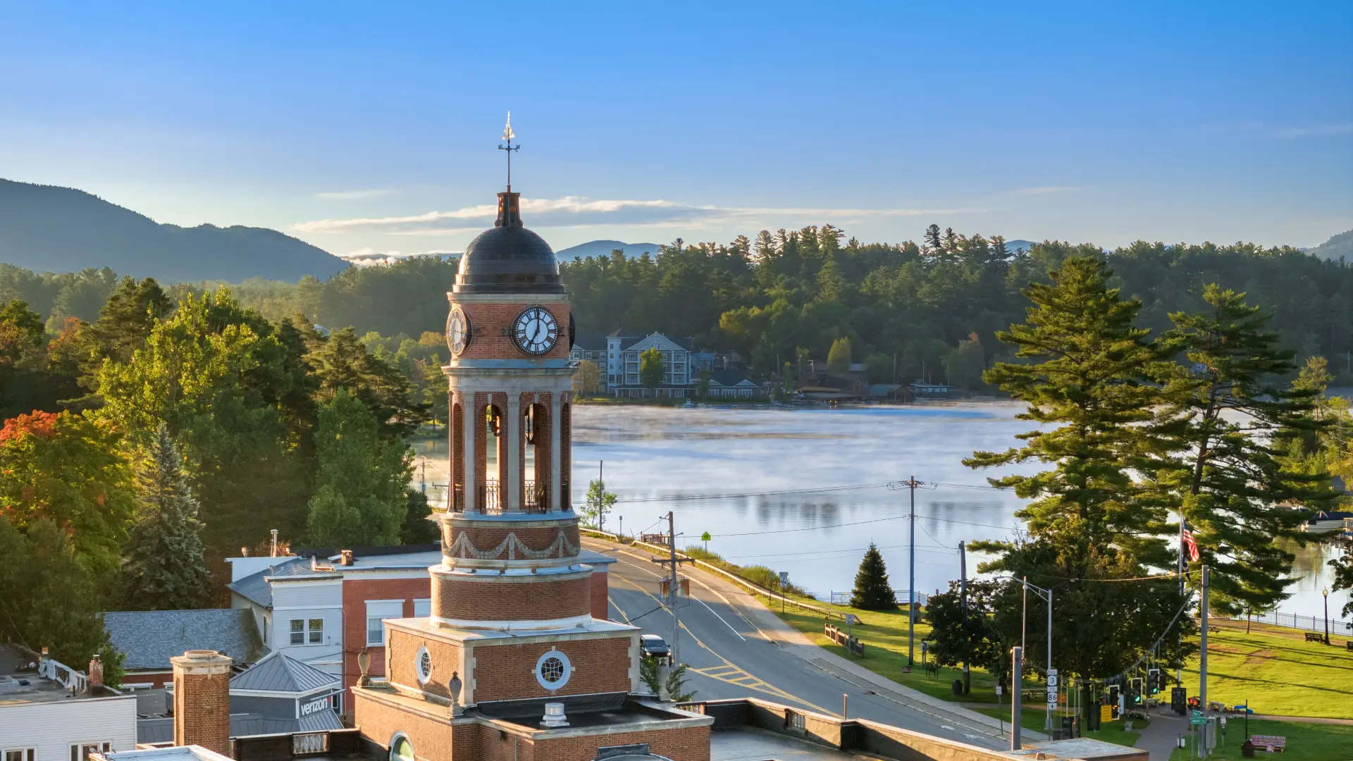 A backed up aerial view of the clock tower at the Harrietstown Town Hall; looking to Lake Flower