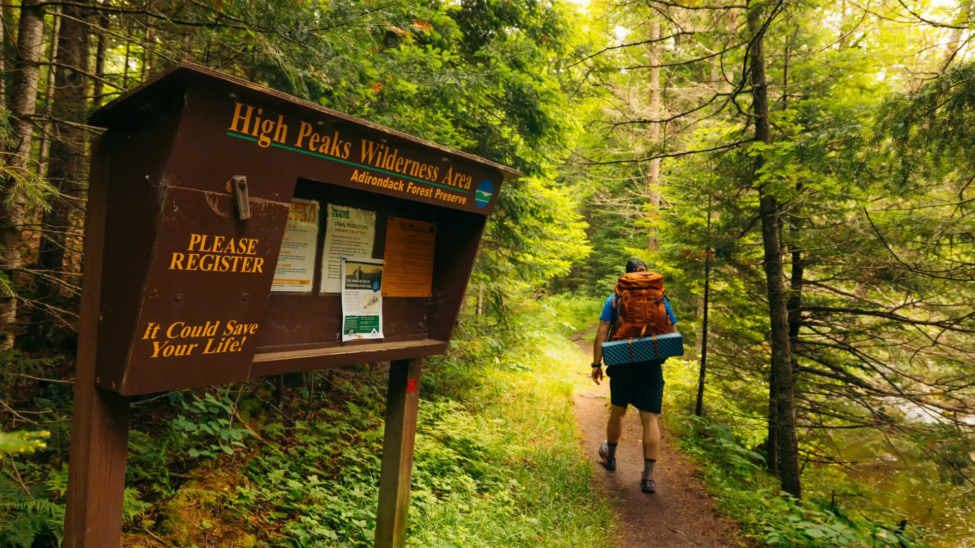 A hiker walking into the woods from the trail register