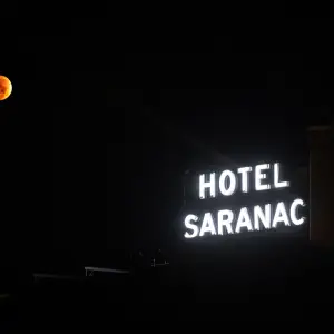 Hotel Saranac signage with a lunar eclipse pictured behind.