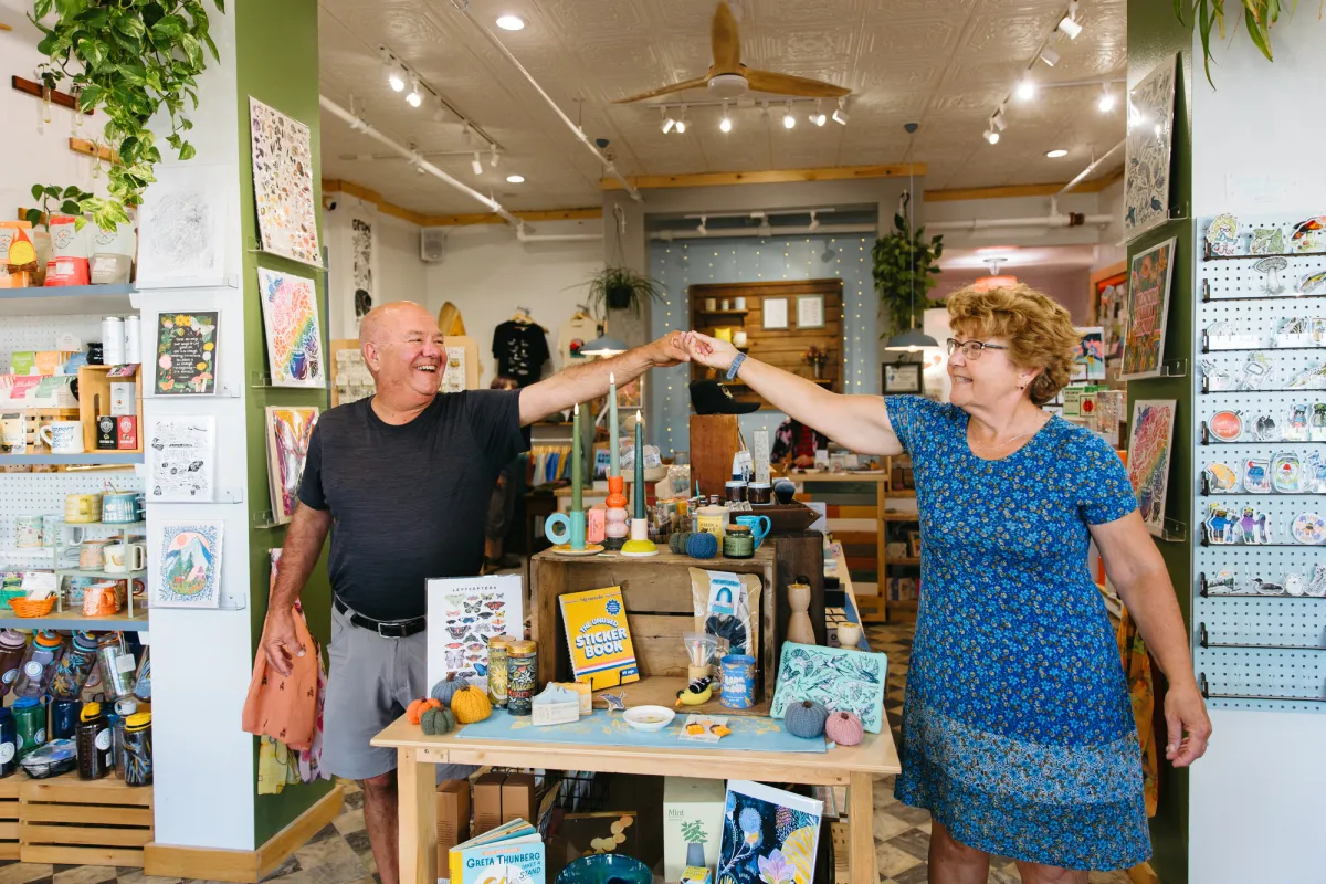 An older man and woman walk around a gift shop.